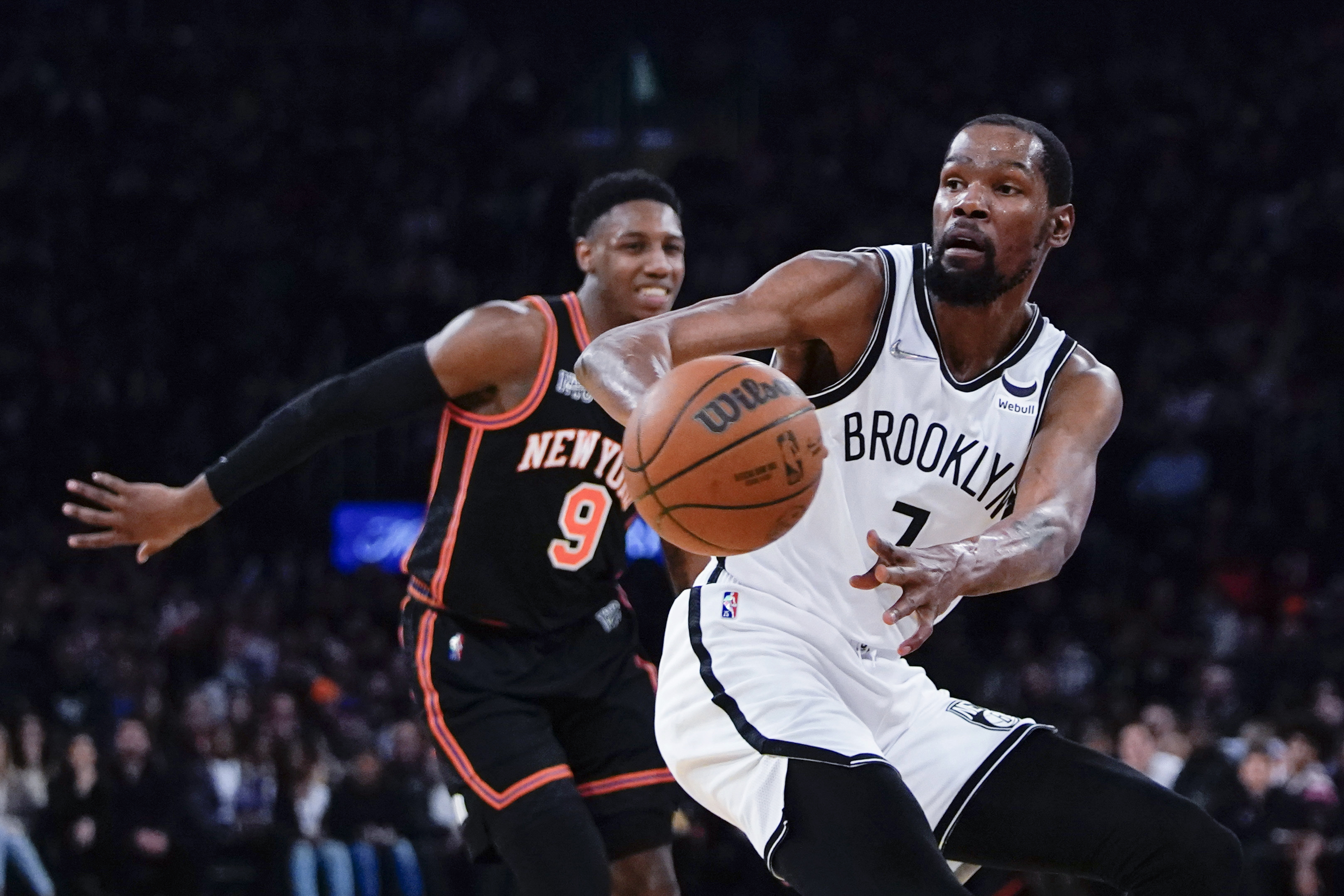 Brooklyn Nets' Kevin Durant (7) passes the ball away from New York Knicks' RJ Barrett (9) during the first half of an NBA basketball game Wednesday, April 6, 2022, in New York. 