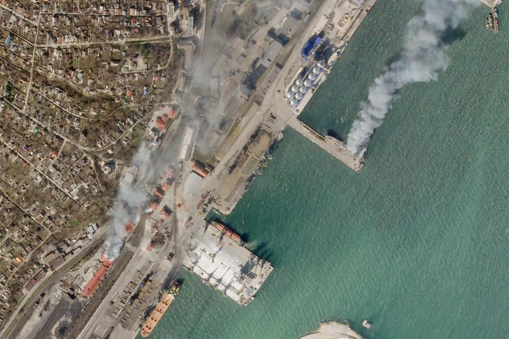 In this satellite photo, a Ukrainian naval vessel and a nearby building burn in the besieged city of Mariupol, Ukraine, Wednesday. The photo appears to show the Ukrainian command ship Donbas burning at the port in Mariupol, as a nearby building also burned around 2:30 p.m. local time Wednesday. A cause for the fire remained unclear.
