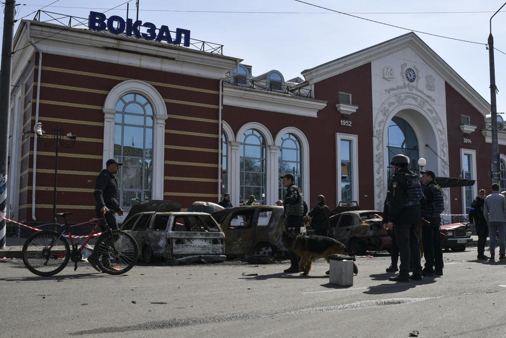 Ukrainian servicemen stand next to damaged cars after Russian shelling at the railway station in Kramatorsk, Ukraine, Friday. Hours after warning that Ukraine's forces already had found worse scenes of brutality in a settlement north of Kyiv, President Volodymyr Zelenskyy said that “thousands” of people were at the station in Kramatorsk, a city in the eastern Donetsk region, when it was hit by a missile.