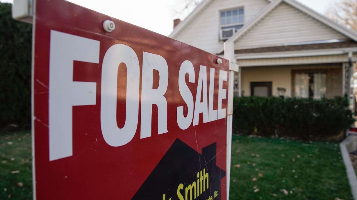 A “for sale” sign is displayed outside of a house in the Sugar House neighborhood of Salt Lake City, Dec. 7, 2021. Utah real estate remains a stanch seller’s market, where big prices can bring sellers big profits. But for some property owners, this could mean a bigger tax bill, too.