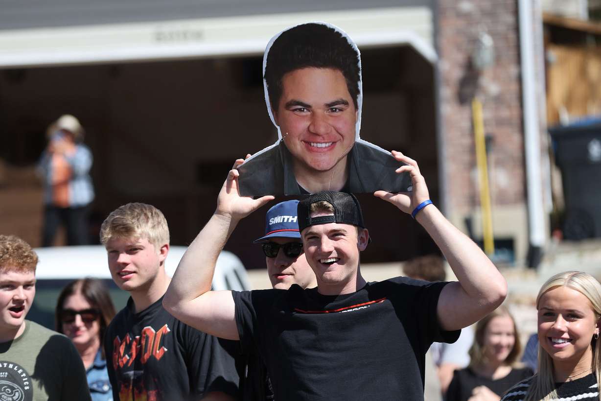 Kord Shaw holds a photo of Max Togisala as Togisala returns home in Ogden on Thursday after receiving care for a paralyzing ski injury. Togisala was greeted by family, friends and members of the community.