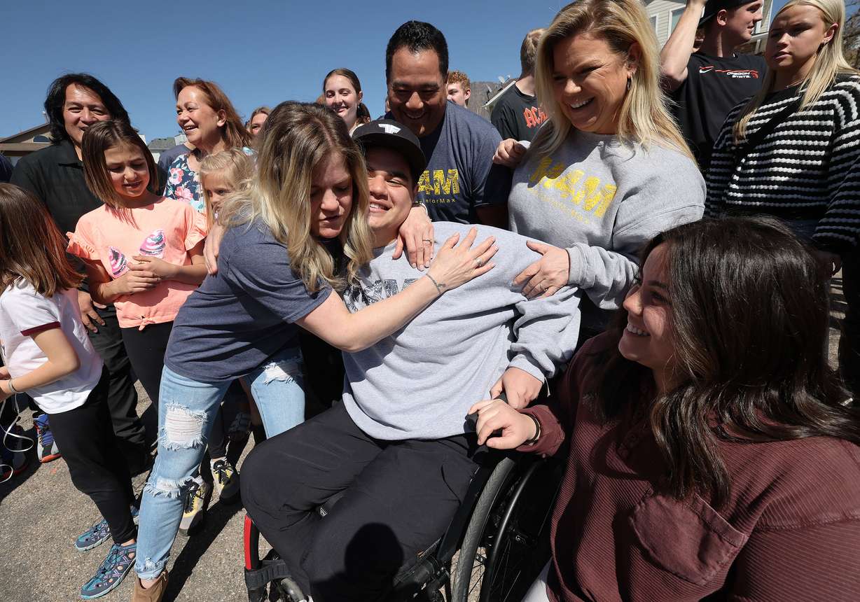 Aimee Krey hugs her nephew, Max Togisala, as returns home in Ogden on Thursday after receiving care for a paralyzing ski injury. Togisala was greeted by family, friends and members of the community.