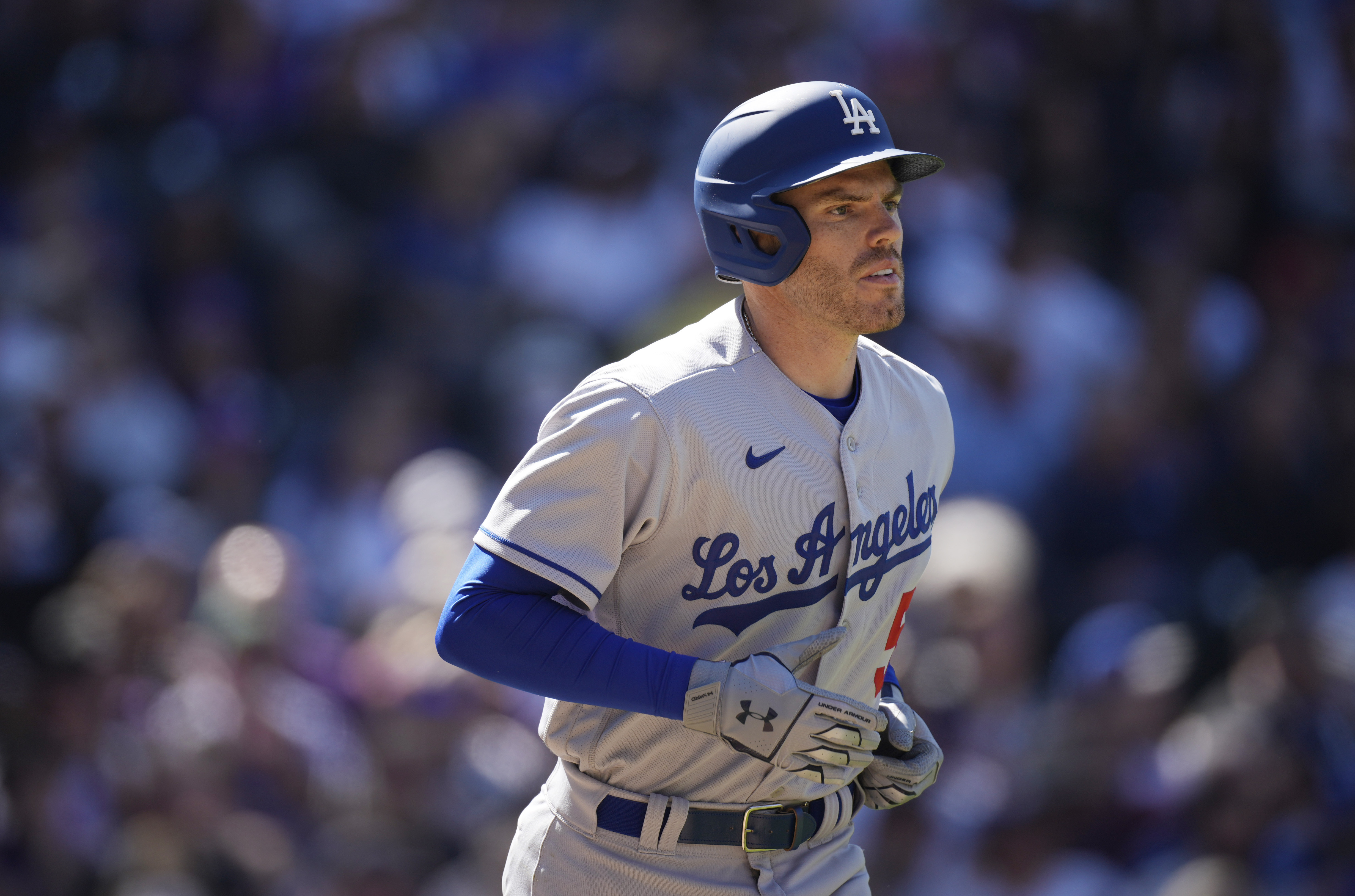 Los Angeles Dodgers' Freddie Freeman heads to first base after getting hit in the back by a pitch from Colorado Rockies starting pitcher Kyle Freeland in the third inning of a baseball game Friday, April 8, 2022, in Denver.