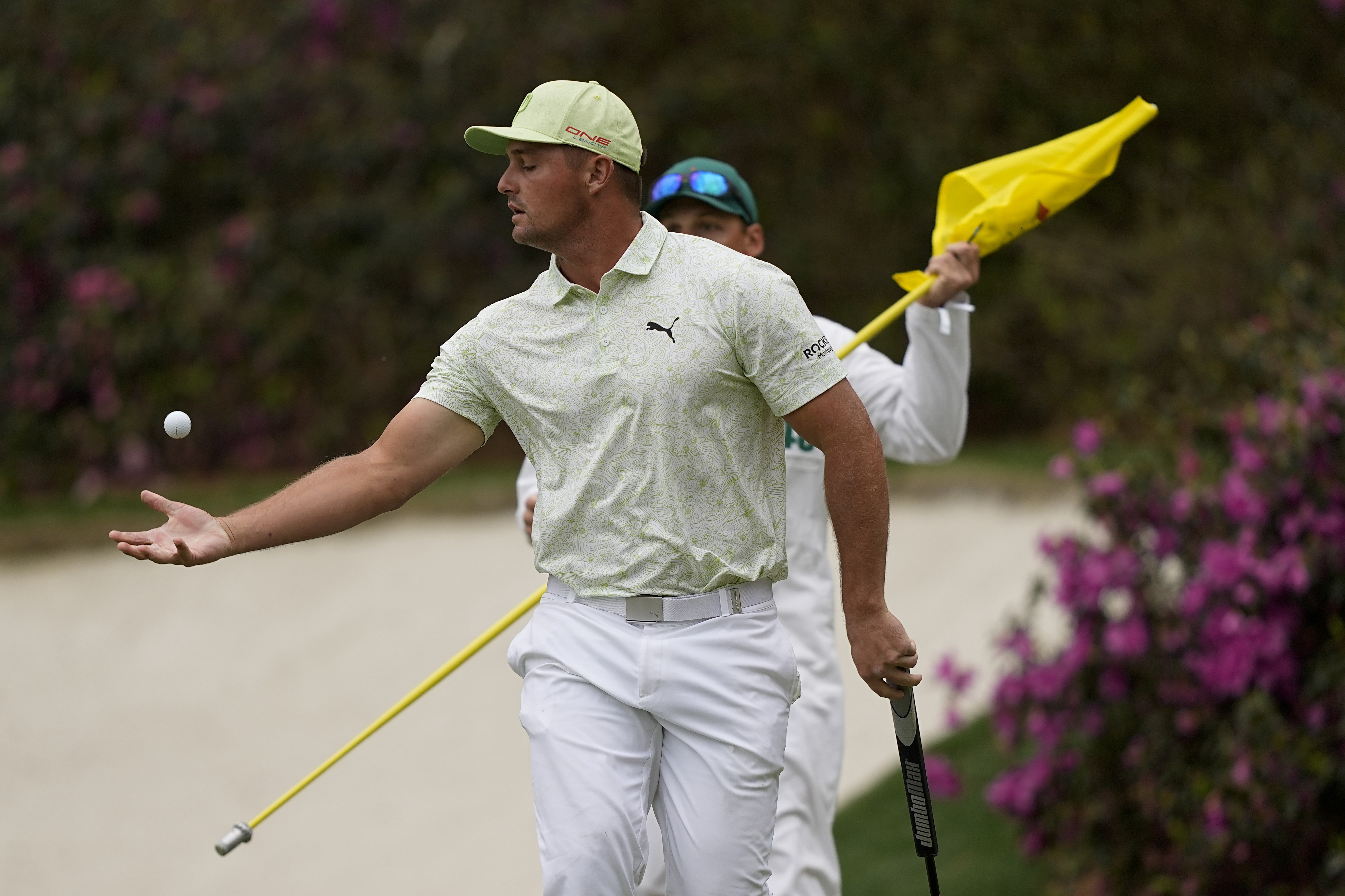 Bryson DeChambeau reaches out to catch his ball after putting on the 13th green during the second round at the Masters golf tournament on Friday, April 8, 2022, in Augusta, Ga. 