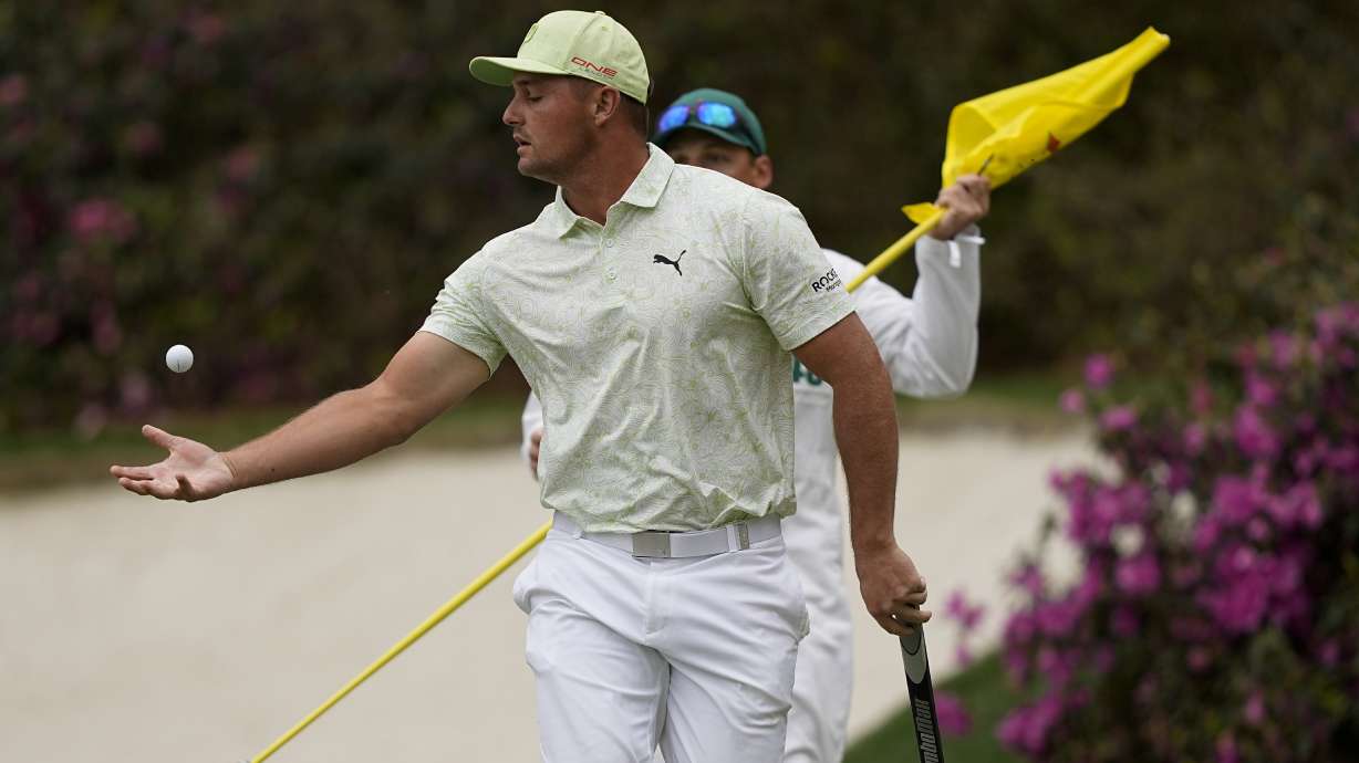 Bryson DeChambeau reaches out to catch his ball after putting on the 13th green during the second round at the Masters golf tournament on Friday, April 8, 2022, in Augusta, Ga.