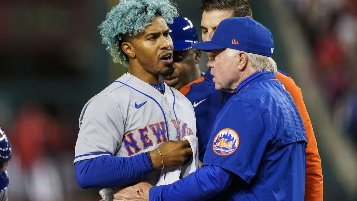 New York Mets shortstop Francisco Lindor, left, is pulled from the game by manager Buck Showalter, right, after he was hit by a pitch during the fifth inning of a baseball game against the Washington Nationals at Nationals Park, Friday, April 8, 2022, in Washington.