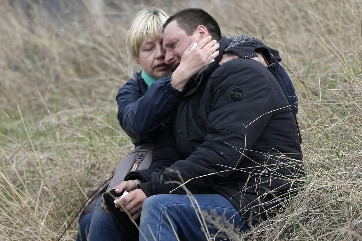 Relatives cry at the mass grave of civilians killed during the Russian occupation in Bucha, on the outskirts of Kyiv, Ukraine, Friday. An international organization formed to identify the dead and missing from the 1990s Balkan conflicts is preparing to send a team of forensics experts to Ukraine as the death toll mounts more than six weeks into the war caused by Russia's invasion.