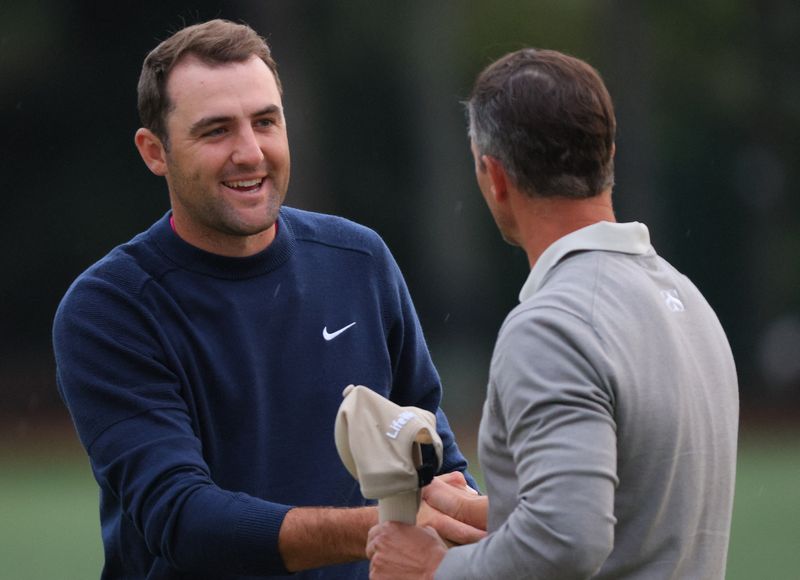 Golf - The Masters - Augusta National Golf Club - Augusta, Georgia, U.S. - April 8, 2022 Scottie Scheffler of the U.S. shakes hands with Australia's Adam Scott on the 18th green after the second round