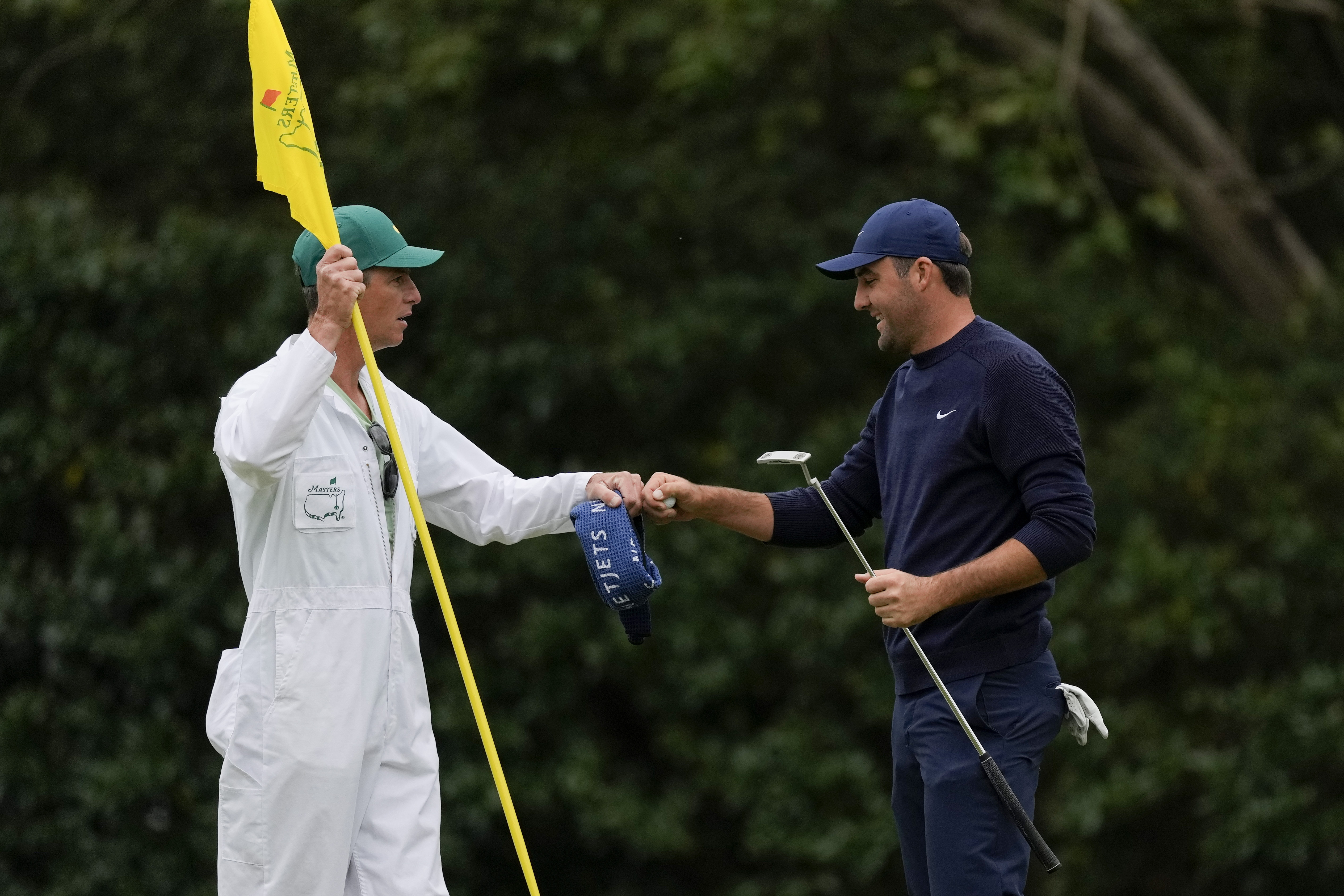 Scottie Scheffler pumps fist with his caddie Ted Scott after putting on the 11th green during the second round at the Masters golf tournament on Friday, April 8, 2022, in Augusta, Ga. 