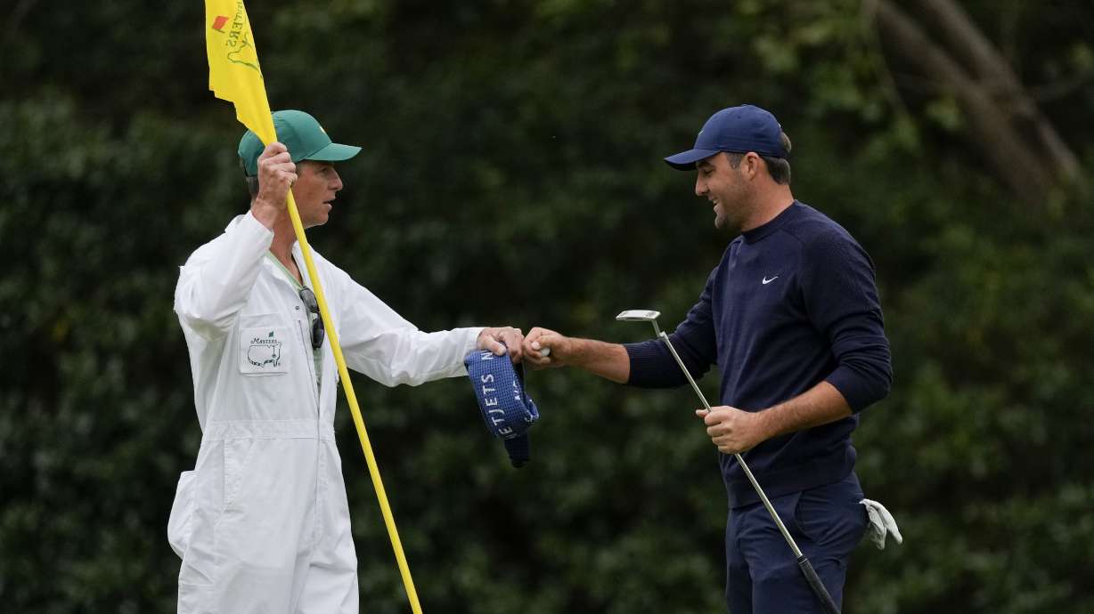 Scottie Scheffler pumps fist with his caddie Ted Scott after putting on the 11th green during the second round at the Masters golf tournament on Friday, April 8, 2022, in Augusta, Ga.