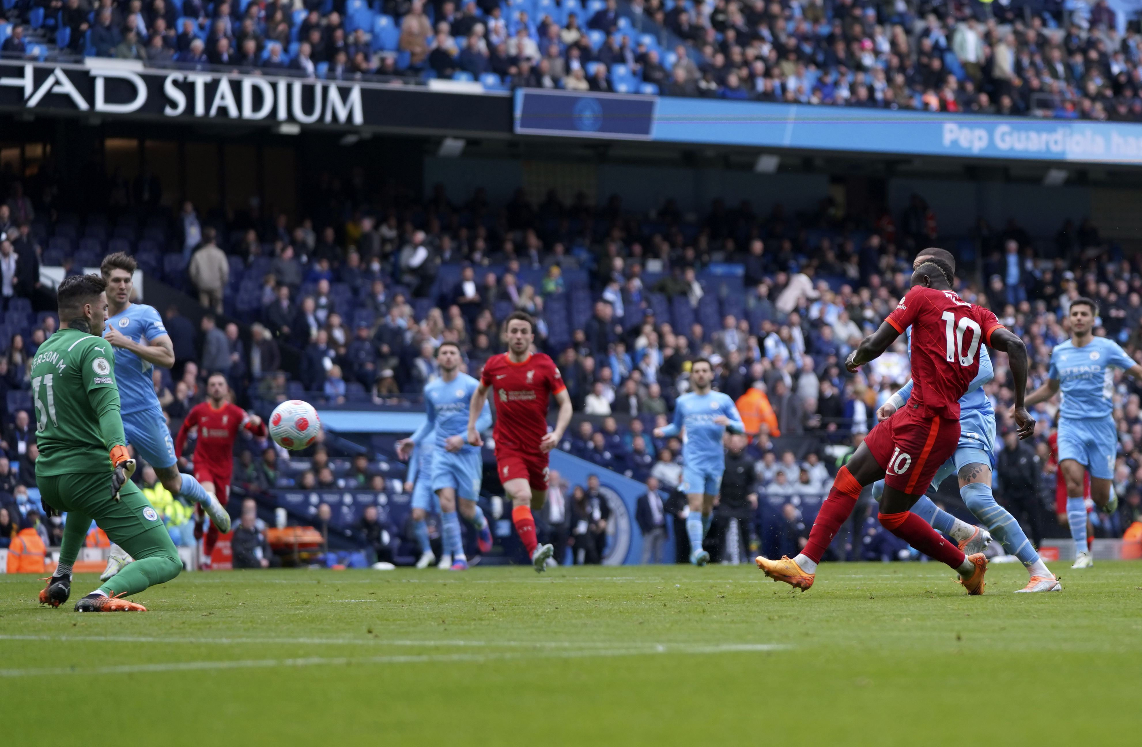 Liverpool's Sadio Mane, right, scores his side's second goal during the English Premier League soccer match between Manchester City and Liverpool, at the Etihad stadium in Manchester, England, Sunday, April 10, 2022. 