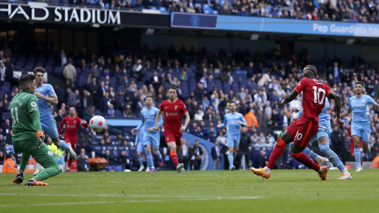 Liverpool's Sadio Mane, right, scores his side's second goal during the English Premier League soccer match between Manchester City and Liverpool, at the Etihad stadium in Manchester, England, Sunday, April 10, 2022.