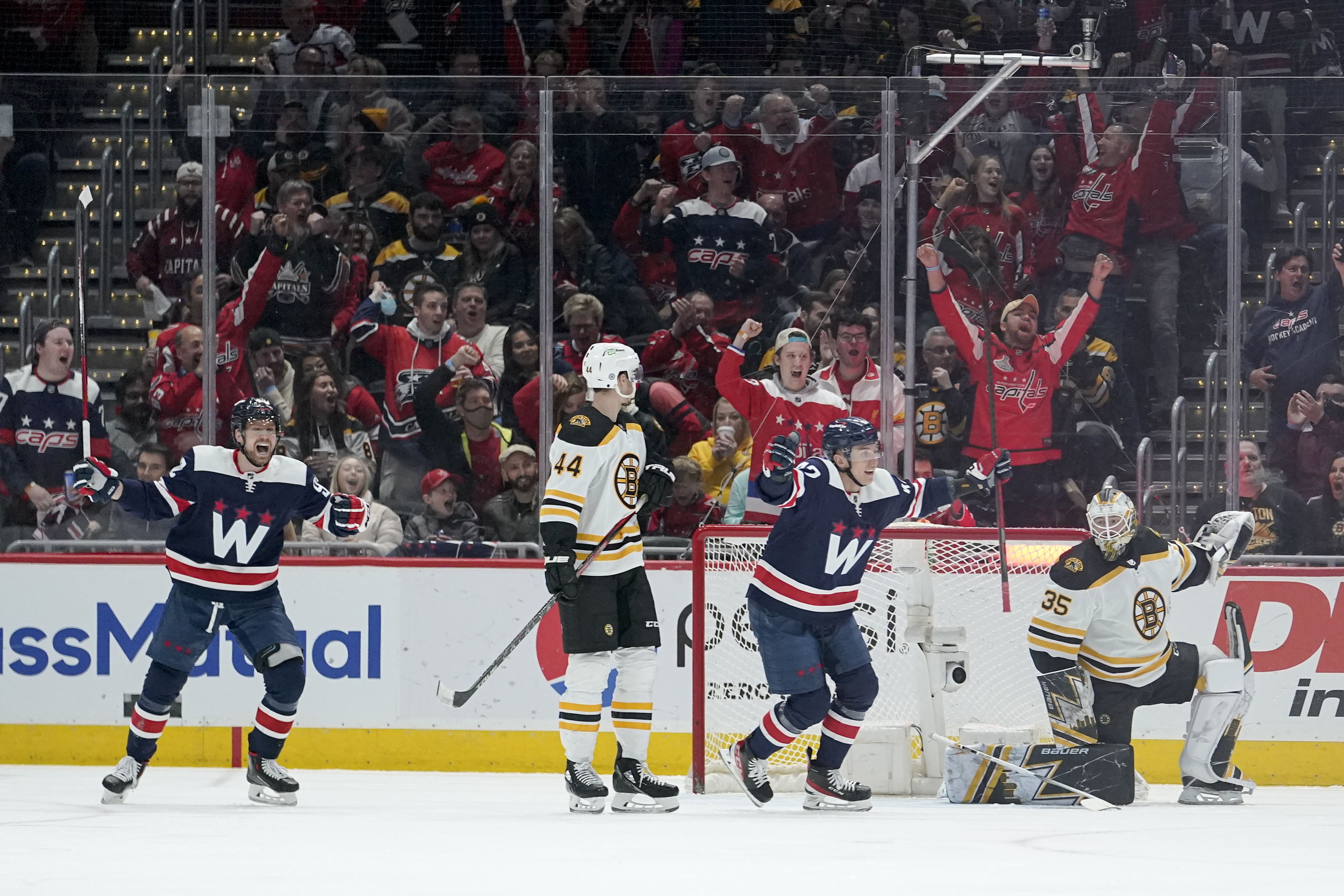 Washington Capitals center Evgeny Kuznetsov, far left, and defenseman Martin Fehervary, center, right, react after teammate John Carlson scored a goal against the Boston Bruins during the second period of an NHL hockey game, Sunday, April 10, 2022, in Washington. Looking on are Boston Bruins' Josh Brown (44) and goaltender Linus Ullmark (35). 