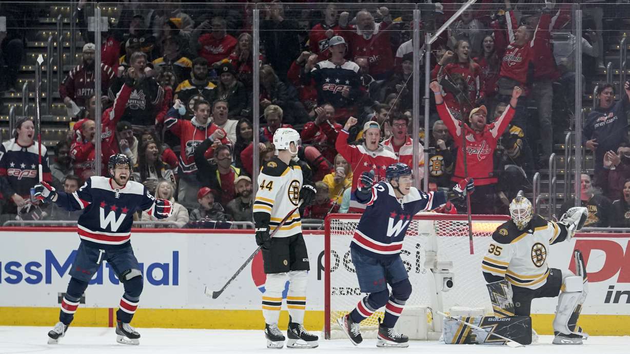Washington Capitals center Evgeny Kuznetsov, far left, and defenseman Martin Fehervary, center, right, react after teammate John Carlson scored a goal against the Boston Bruins during the second period of an NHL hockey game, Sunday, April 10, 2022, in Washington. Looking on are Boston Bruins' Josh Brown (44) and goaltender Linus Ullmark (35).