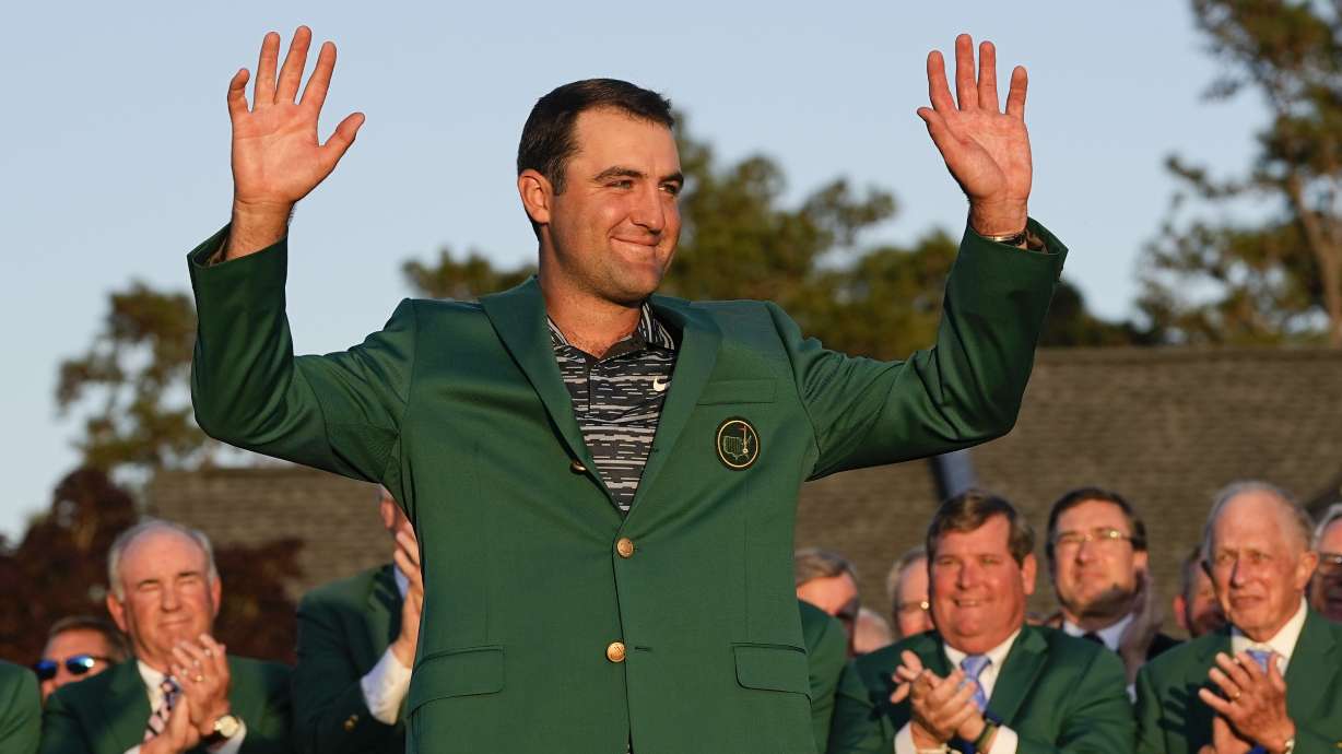 Scottie Scheffler celebrates after putting on the green jacket after winning the 86th Masters golf tournament on Sunday, April 10, 2022, in Augusta, Ga.