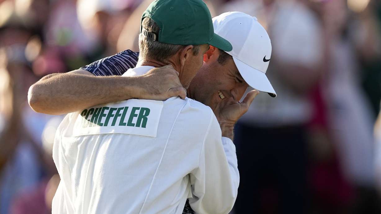 Scottie Scheffler hugs his caddie Ted Scott after winning the 86th Masters golf tournament on Sunday, April 10, 2022, in Augusta, Ga.