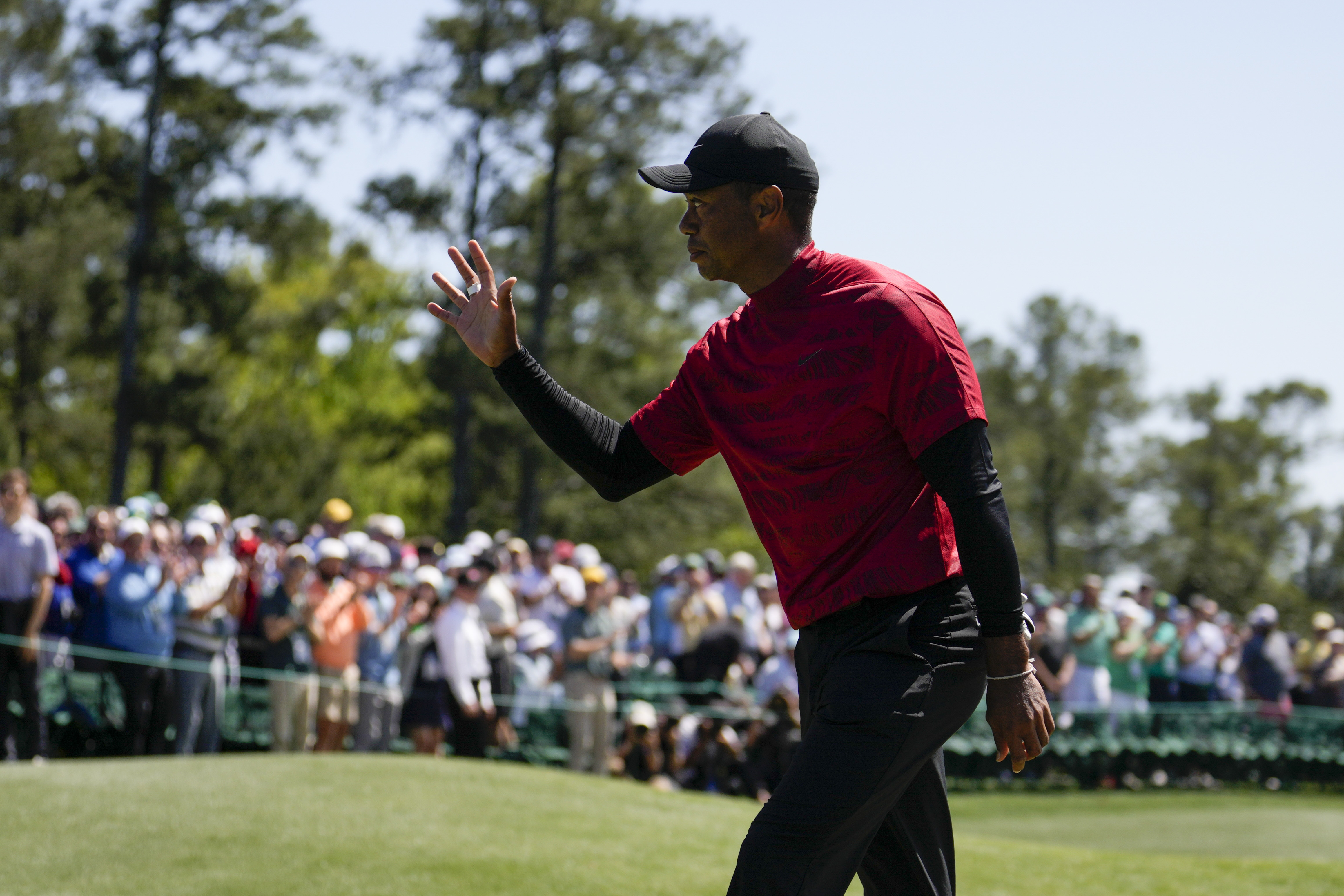 Tiger Woods waves to spectators on the 18th green after his final round at the Masters golf tournament on Sunday, April 10, 2022, in Augusta, Ga. 