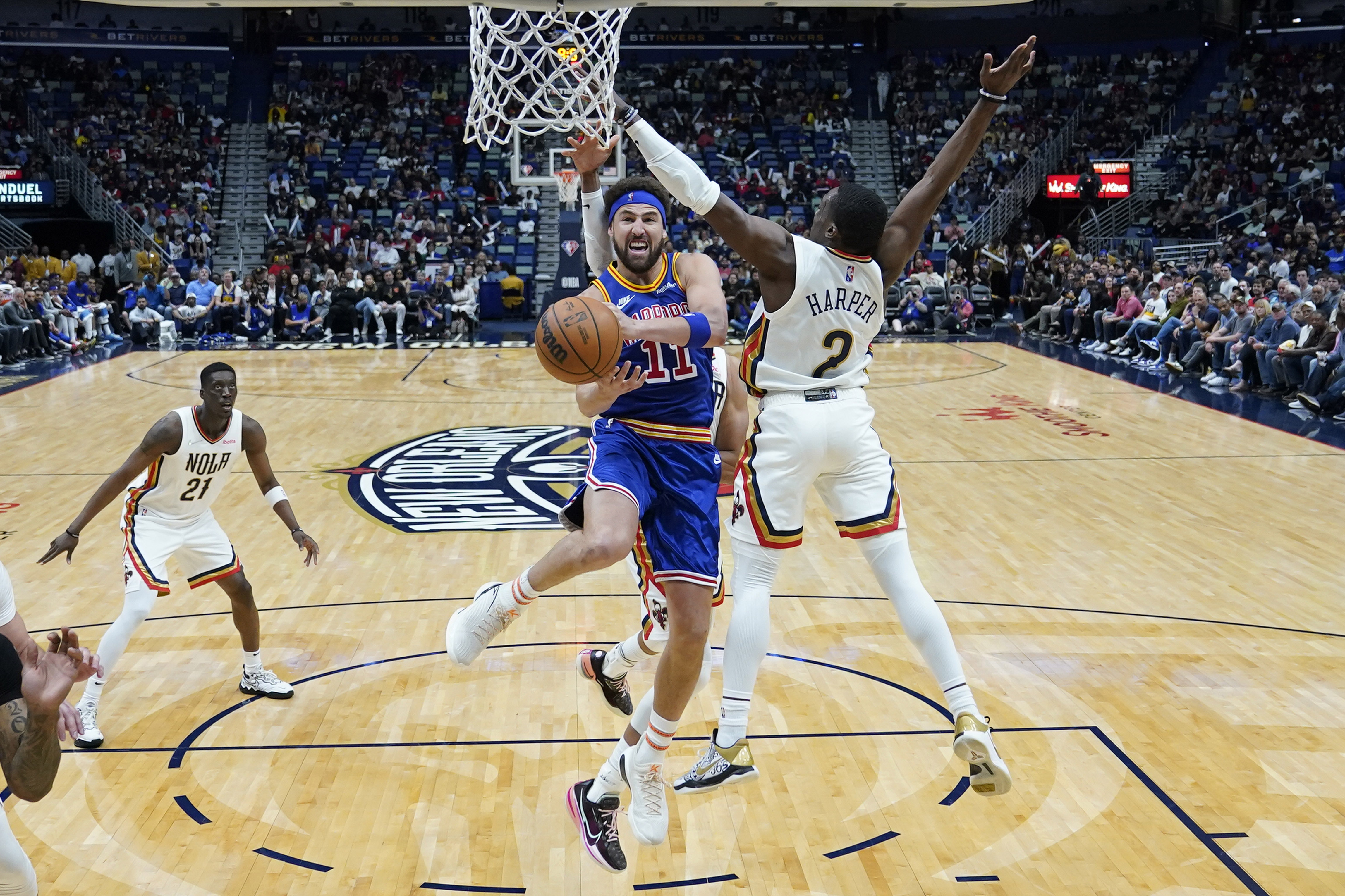Golden State Warriors guard Klay Thompson (11) goes to the basket against New Orleans Pelicans guard Jared Harper (2) in the second half of an NBA basketball game in New Orleans, Sunday, April 10, 2022. The Warriors won 128-107. 