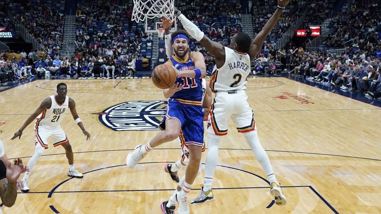 Golden State Warriors guard Klay Thompson (11) goes to the basket against New Orleans Pelicans guard Jared Harper (2) in the second half of an NBA basketball game in New Orleans, Sunday, April 10, 2022. The Warriors won 128-107.