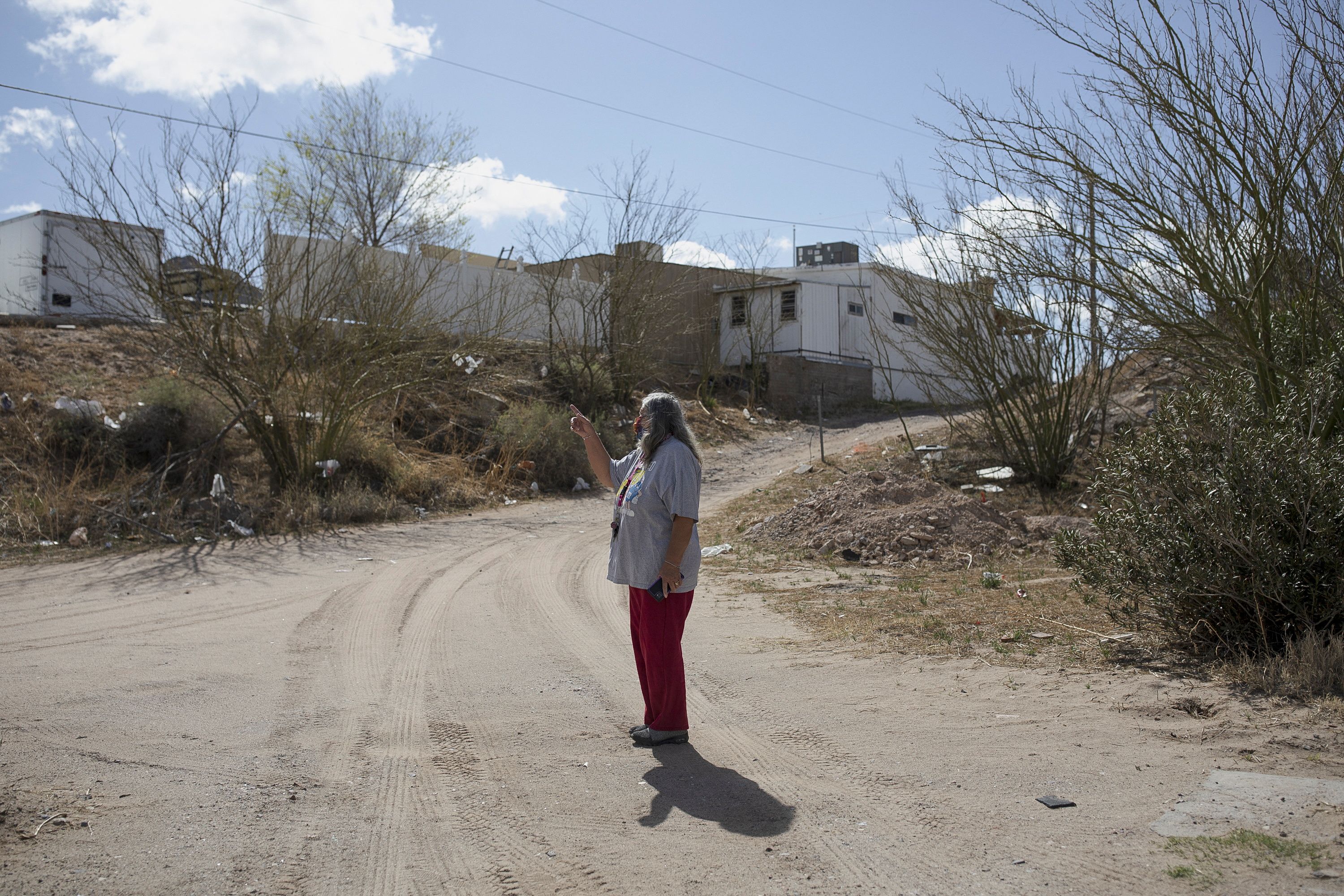 Maria, whose last name she didn’t want used, shows her property where she says migrants hide as they await rides in Sunland Park, New Mexico, March 23. A growing number of U.S. teenagers in communities from Texas to California are being recruited to transport migrants crossing the Southwest border, according to U.S. Customs and Border Protection.
