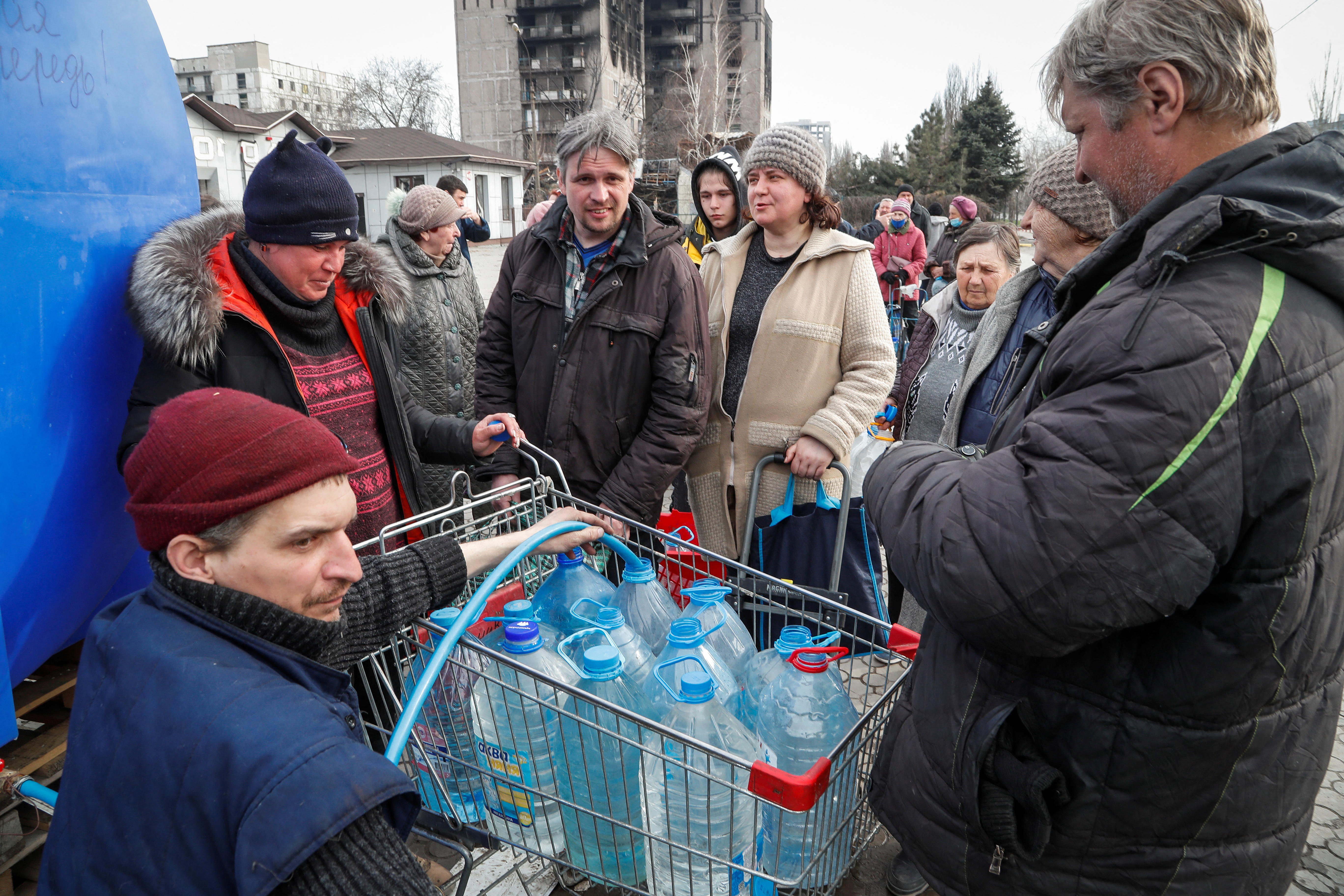 Residents queue to get water during the Ukraine-Russia conflict, in the southern port city of Mariupol, Ukraine, Sunday. Ukrainian troops have pushed back several Russian assaults in the country's east, British intelligence said on Monday, while President Volodymyr Zelenskyy said tens of thousands of Russian soldiers were massing for a new offensive.