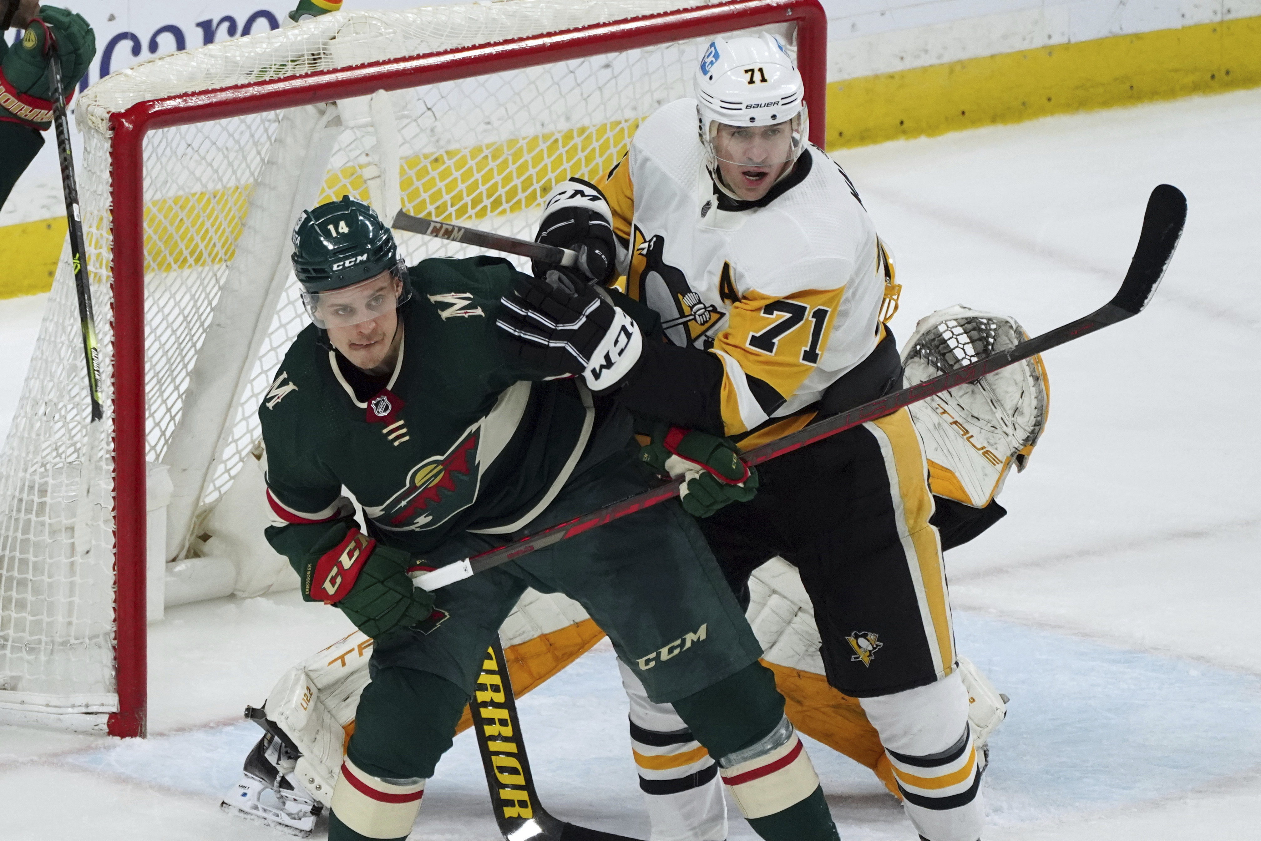 Minnesota Wild's Joel Eriksson Ek (14) looks for a pass as Pittsburgh Penguins' Evgeni Malkin (71) defends during the third period of an NHL hockey game Thursday, March 31, 2022, in St. Paul, Minn. The Penguins won 4-3 in overtime with a goal by Malkin. 