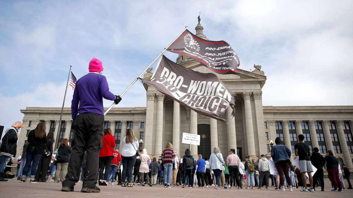 A person holds flags during the Bans Off Oklahoma Rally on the steps of the Oklahoma state Capitol in Oklahoma City, April 5. Oklahoma Gov. Kevin Stitt has signed into law a bill making it a felony to perform an abortion, punishable by up to 10 years in prison. Abortion rights advocates say the bill is clearly unconstitutional and is likely to face a legal challenge.