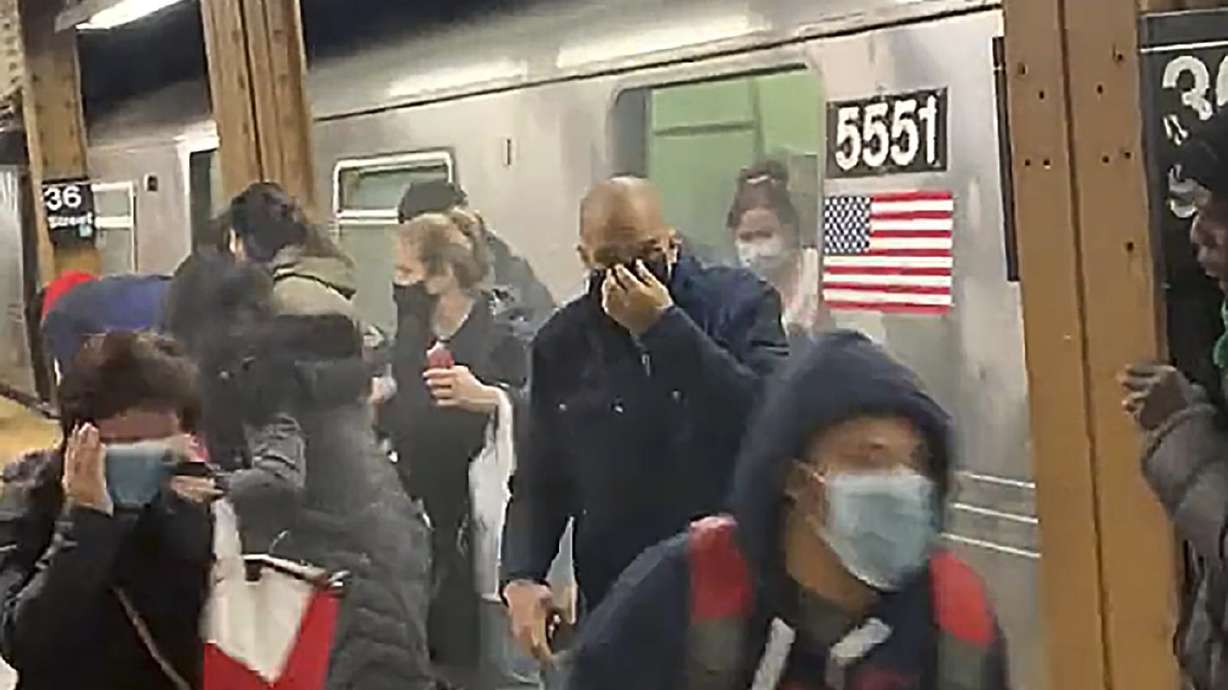In this photo from social media video, passengers run from a subway car in a station in the Brooklyn borough of New York, Tuesday. A gunman filled a rush-hour subway train with smoke and shot multiple people Tuesday, leaving wounded commuters bleeding on a Brooklyn platform as others ran screaming, authorities said. Police were still searching for the suspect.