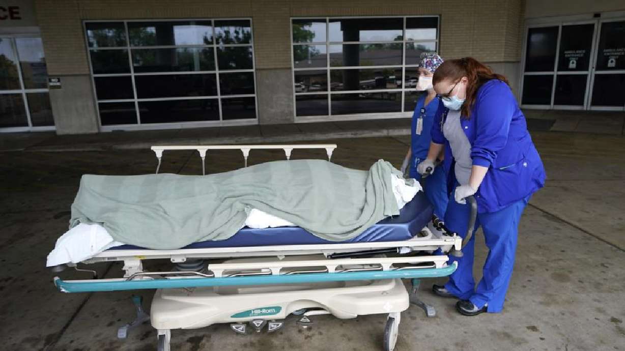 Medical staff prepare to move the body of a deceased COVID-19 patient to a funeral home van at the Willis-Knighton Medical Center in Shreveport, La., Aug. 18, 2021. New data released by the Centers for Disease Control and Prevention confirms that 2021 was the deadliest year in U.S. history.