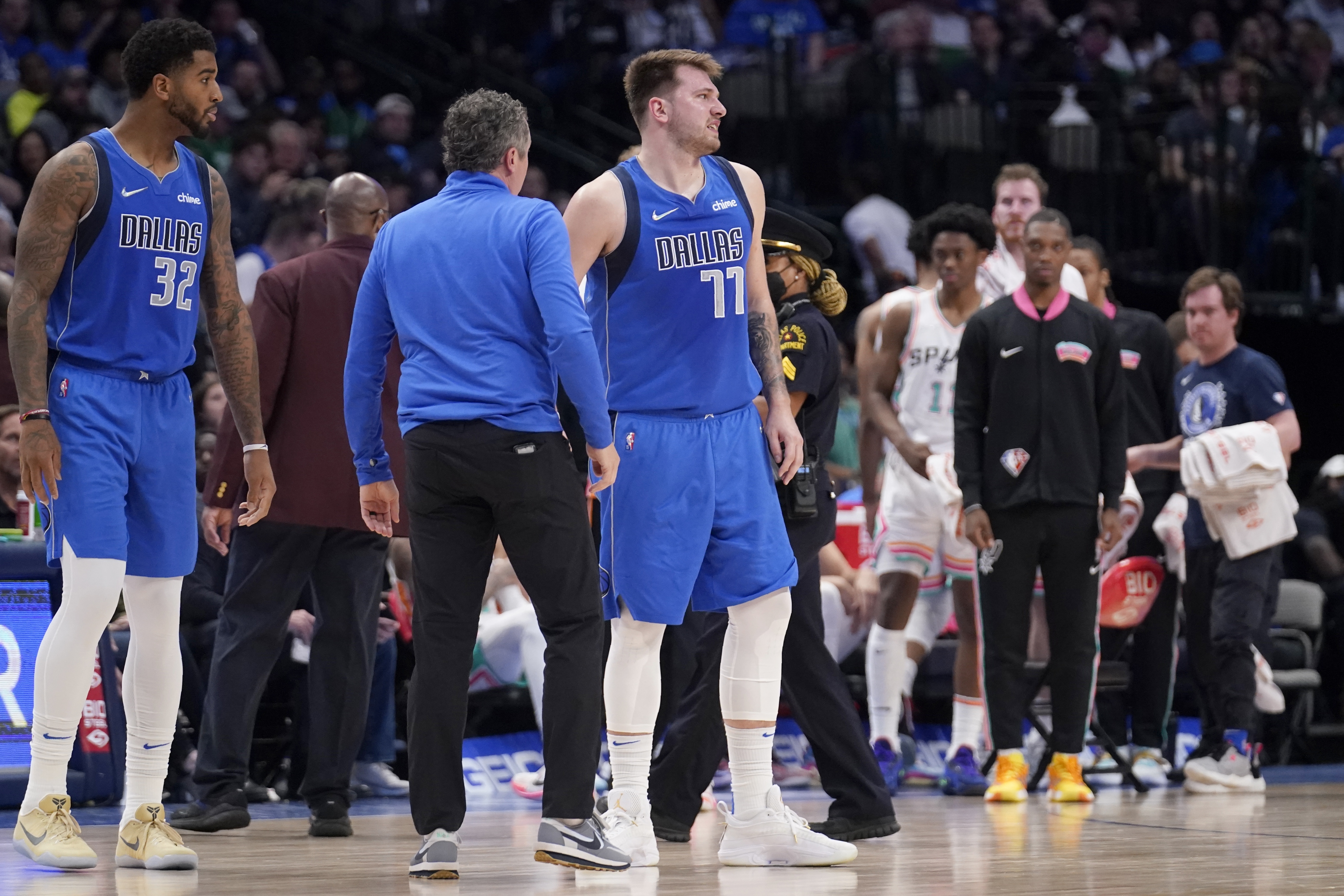 Dallas Mavericks' Marquese Chriss and a member of the staff check on guard Luka Doncic (77) who suffered an unknown lower leg injury in the second half of an NBA basketball game against the San Antonio Spurs, Sunday, April 10, 2022, in Dallas. 