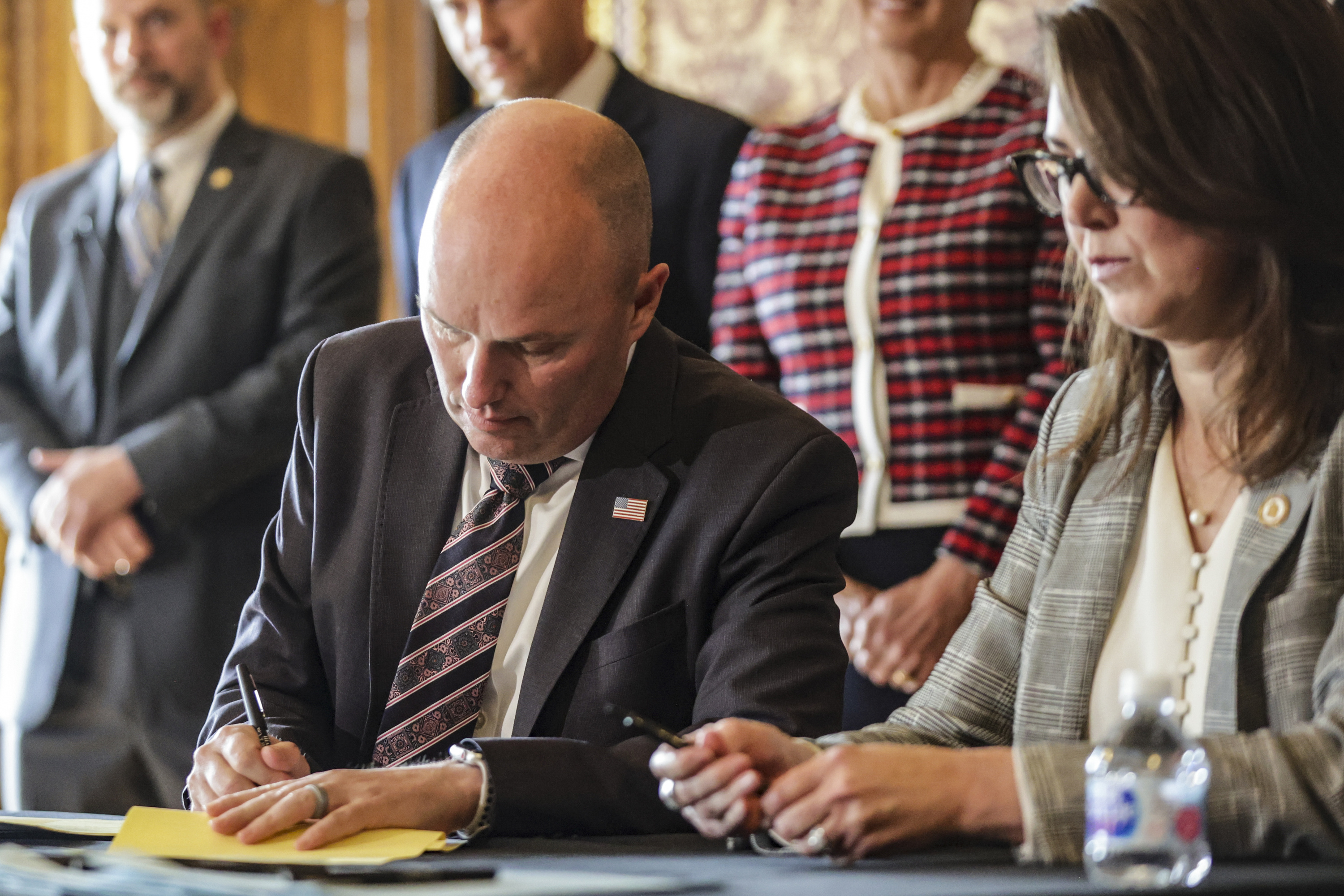 Gov. Spencer Cox, left, and Utah Lt. Gov. Deidre Henderson ceremonially sign SB171 and bills focused on law enforcement and mental health issues at the Capitol in Salt Lake City on Tuesday.