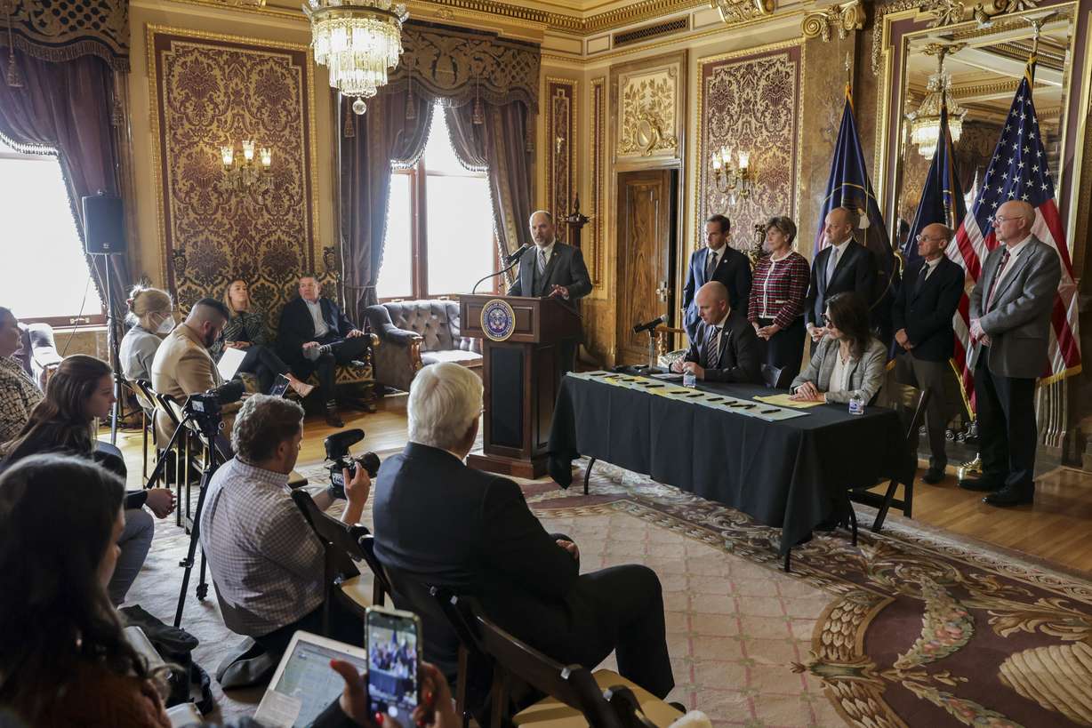 State Sen. Daniel Thatcher, R-West Valley City, front left, speaks before Gov. Spencer Cox and Utah Lt. Gov. Deidre Henderson, seated, ceremonially sign SB171 and other bills focused on law enforcement and mental health issues at the Capitol in Salt Lake City on Tuesday, April 12, 2022. SB171 creates a collaboration between the Huntsman Mental Health Institute and the State Board of Education to develop an age-appropriate curriculum for grades K-12 on behavioral health.