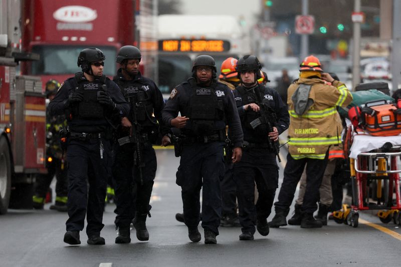 Police officers walk near the scene of a shooting at a subway station in the Brooklyn borough of New York City, Tuesday.