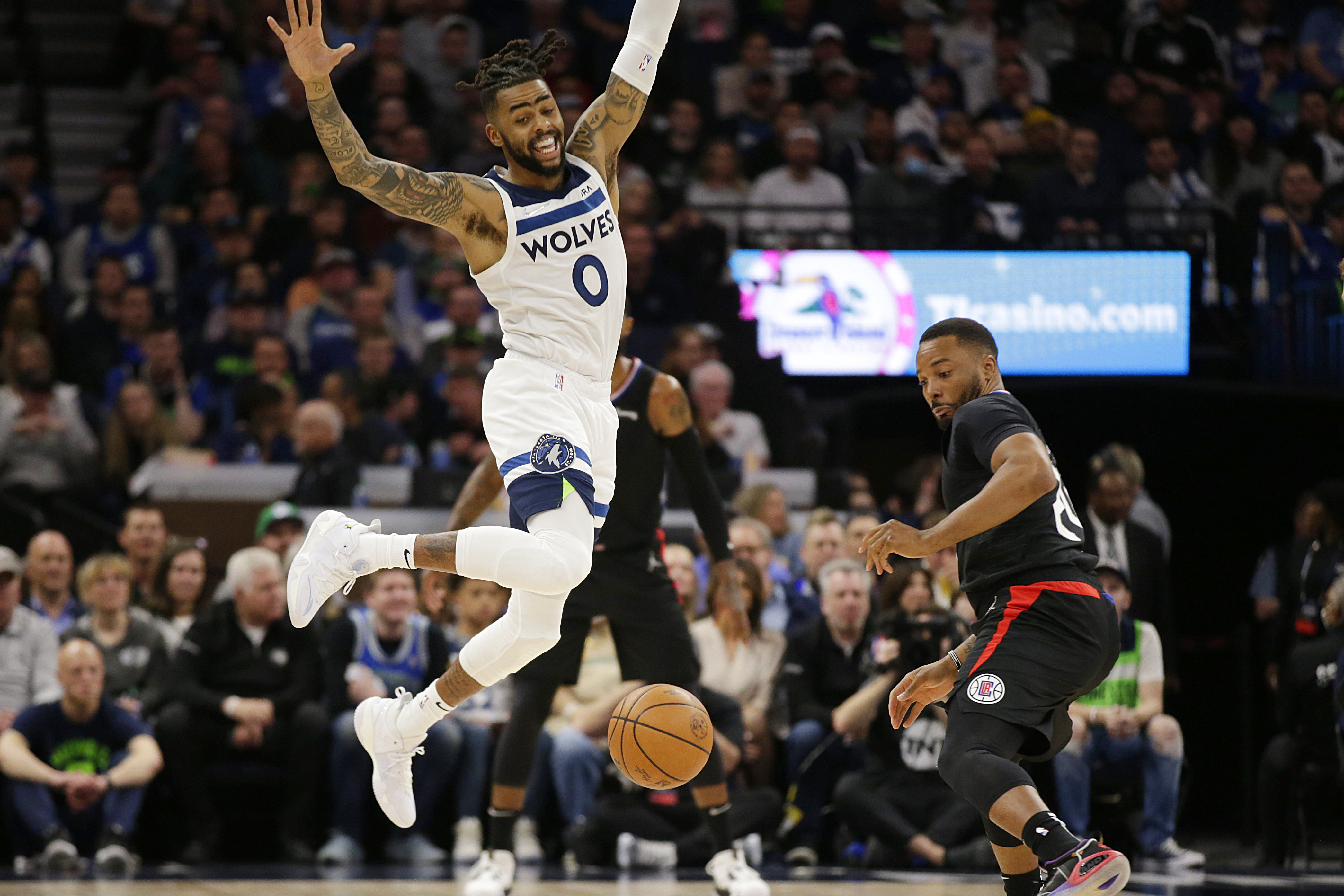 Minnesota Timberwolves guard D'Angelo Russell (0) loses control of the ball while Los Angeles Clippers forward Norman Powell (24) defends during the first quarter during an NBA basketball game Tuesday, April 12, 2022, in Minneapolis. 