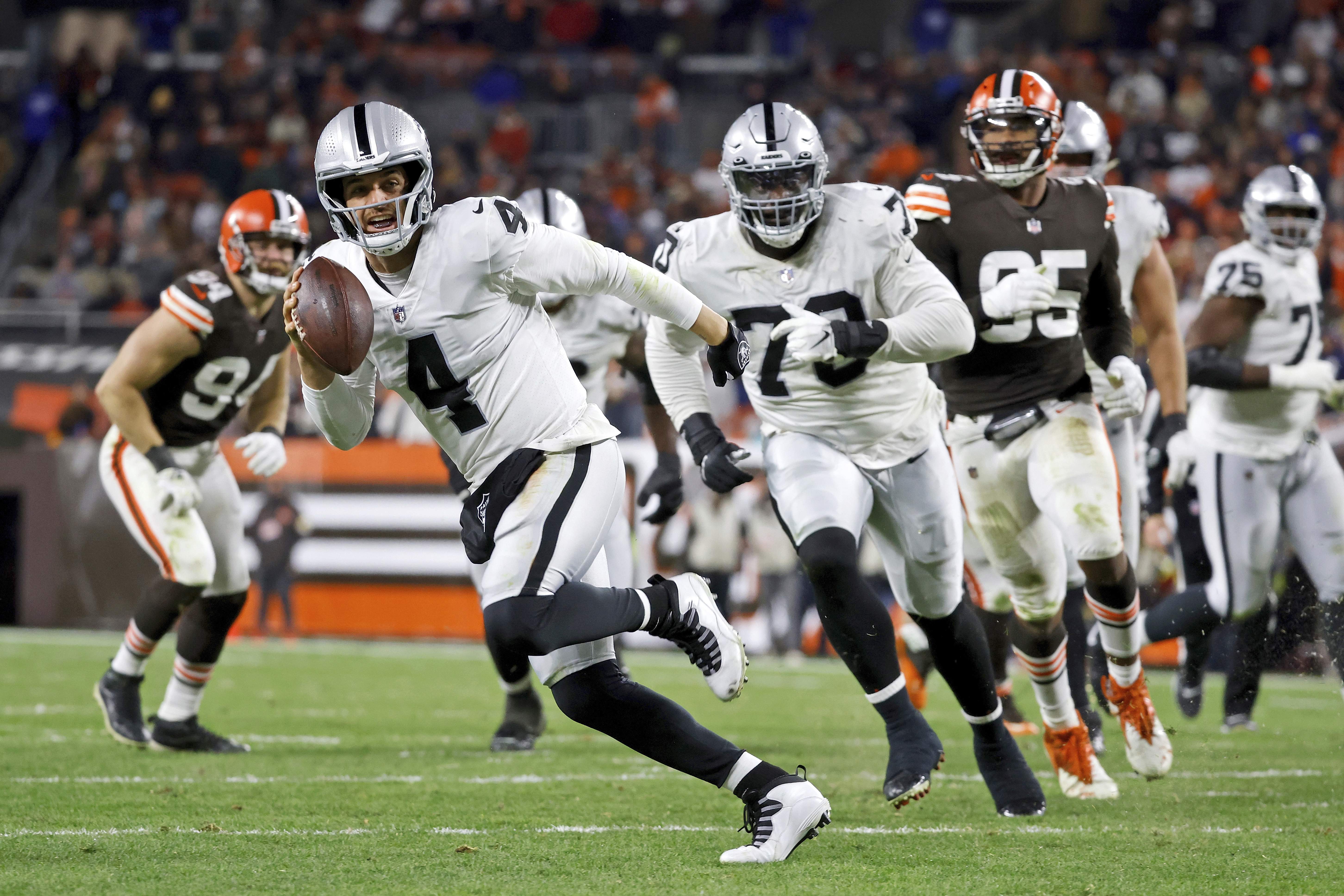 FILE - Las Vegas Raiders quarterback Derek Carr  runs with the ball during an NFL football game against the Cleveland Browns on Monday, Dec. 20, 2021, in Cleveland. The Raiders have given Carr a three-year contract extension, a person with knowledge of the deal tells The Associated Press. The extension is worth $121.5 million, the person said, speaking Wednesday, April 13, 2022, on condition of anonymity because the deal has not been announced.  (AP Photo/Kirk Irwin, File0