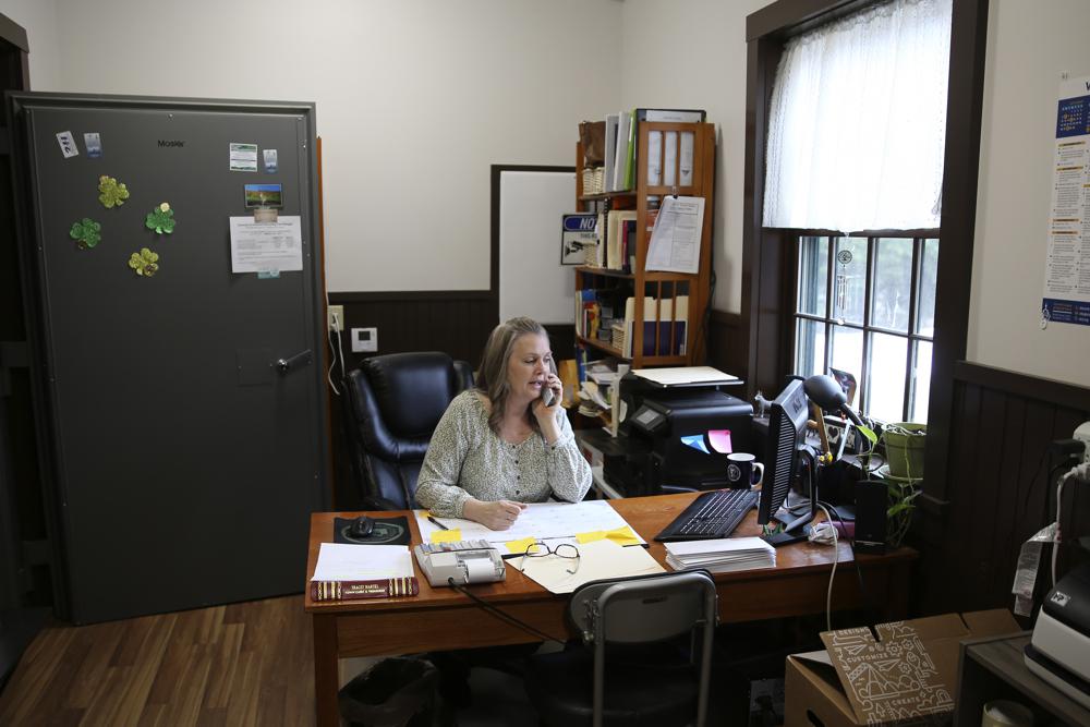 Victory Town Clerk Tracey Martel takes a phone call at the town clerk's office, in Victory, Vt., March 31. Martel says she's regularly frustrated watching a spinning circle on her computer while she tries to complete even the most basic municipal chores online.