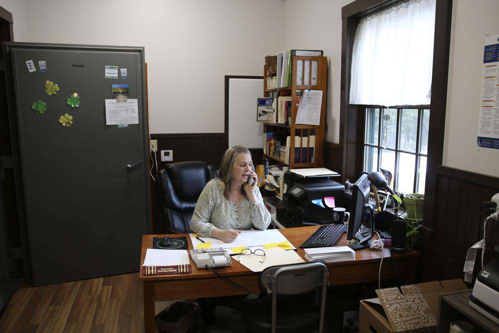 Victory Town Clerk Tracey Martel takes a phone call at the town clerk's office, in Victory, Vt., March 31. Martel says she's regularly frustrated watching a spinning circle on her computer while she tries to complete even the most basic municipal chores online.