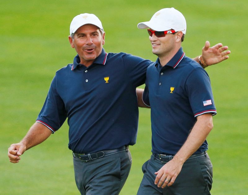 FILE PHOTO: U.S. team captain Fred Couples (L) congratulates Zach Johnson following Johnson's first round win during the opening Four-ball matches for the 2013 Presidents Cup golf tournament at Muirfield Village Golf Club in Dublin, Ohio October 3, 2013.