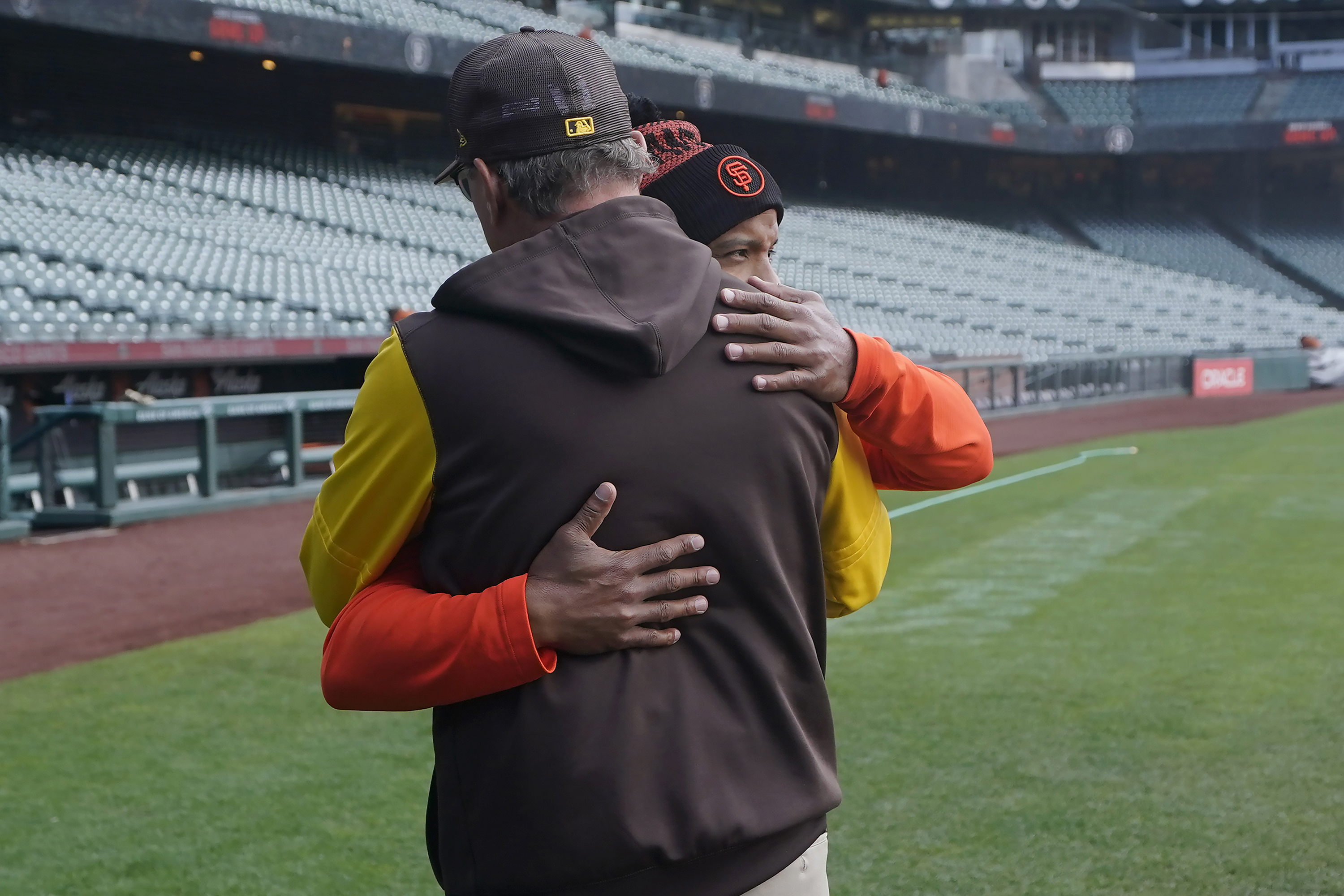 San Diego Padres third base coach Mike Shildt, back to camera, hugs San Francisco Giants first base coach Antoan Richardson after they spoke at a news conference before a baseball game in San Francisco, Wednesday, April 13, 2022. 