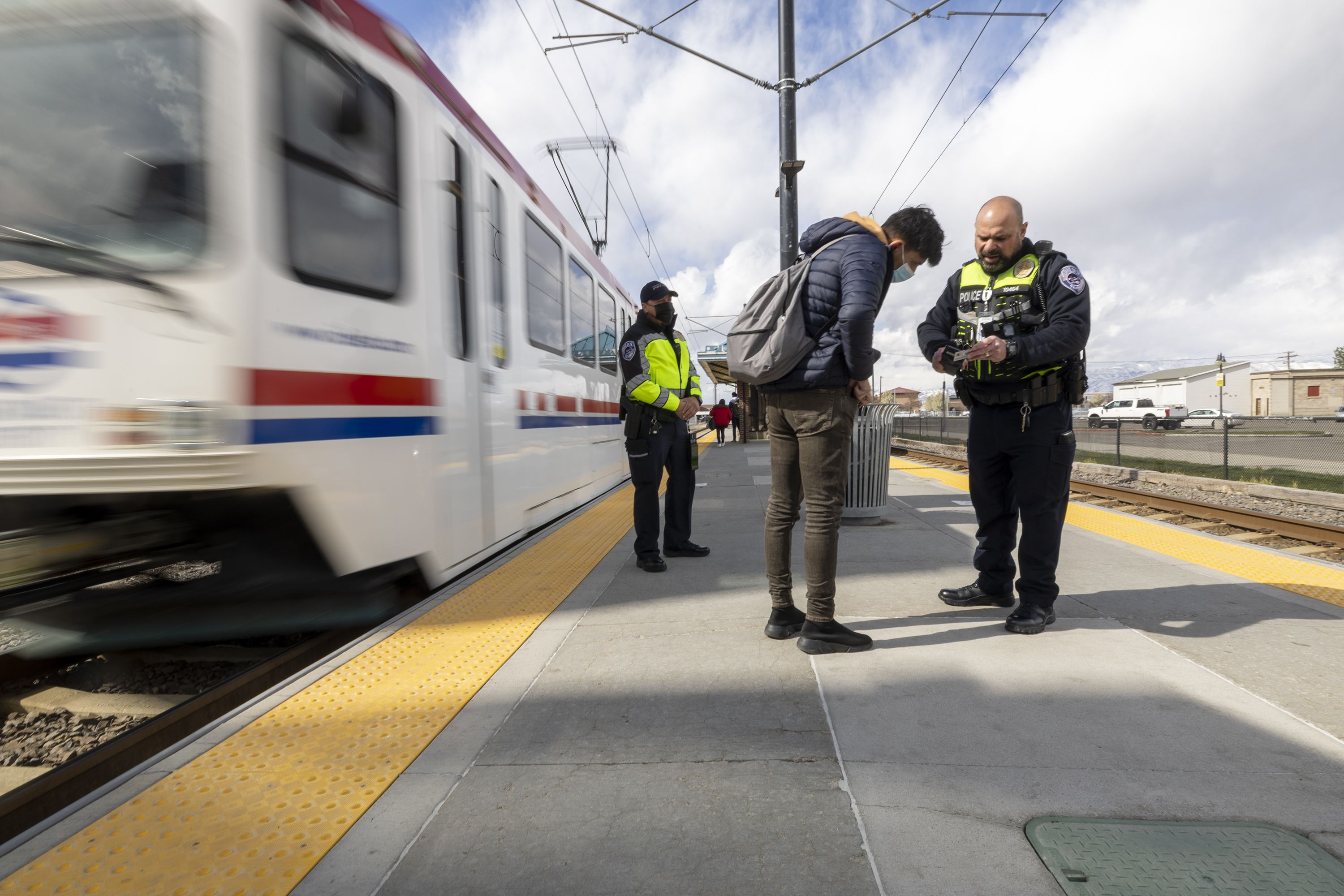 Utah Transit Authority police officer John Lobaido talks with a passenger who didn’t have a ticket as he and Phil Herrera check passenger tickets in the Murray area on Wednesday.