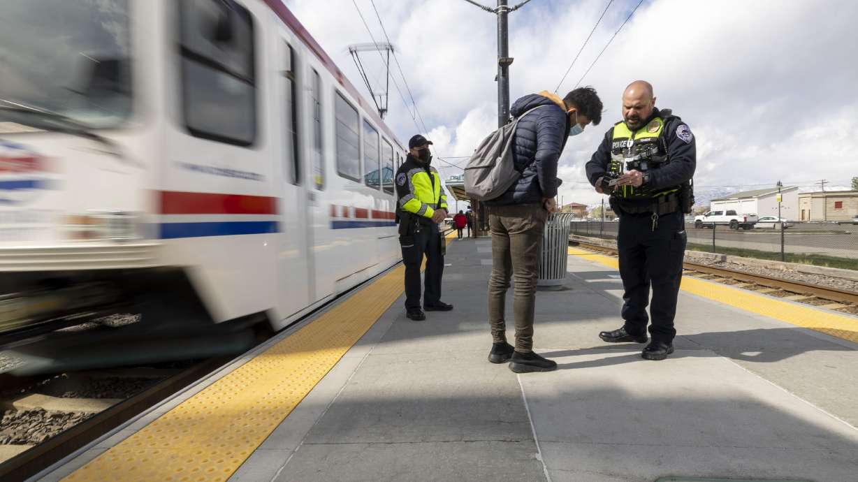 Utah Transit Authority police officer John Lobaido talks with a passenger who didn’t have a ticket as he and Phil Herrera check passenger tickets in the Murray area on Wednesday.