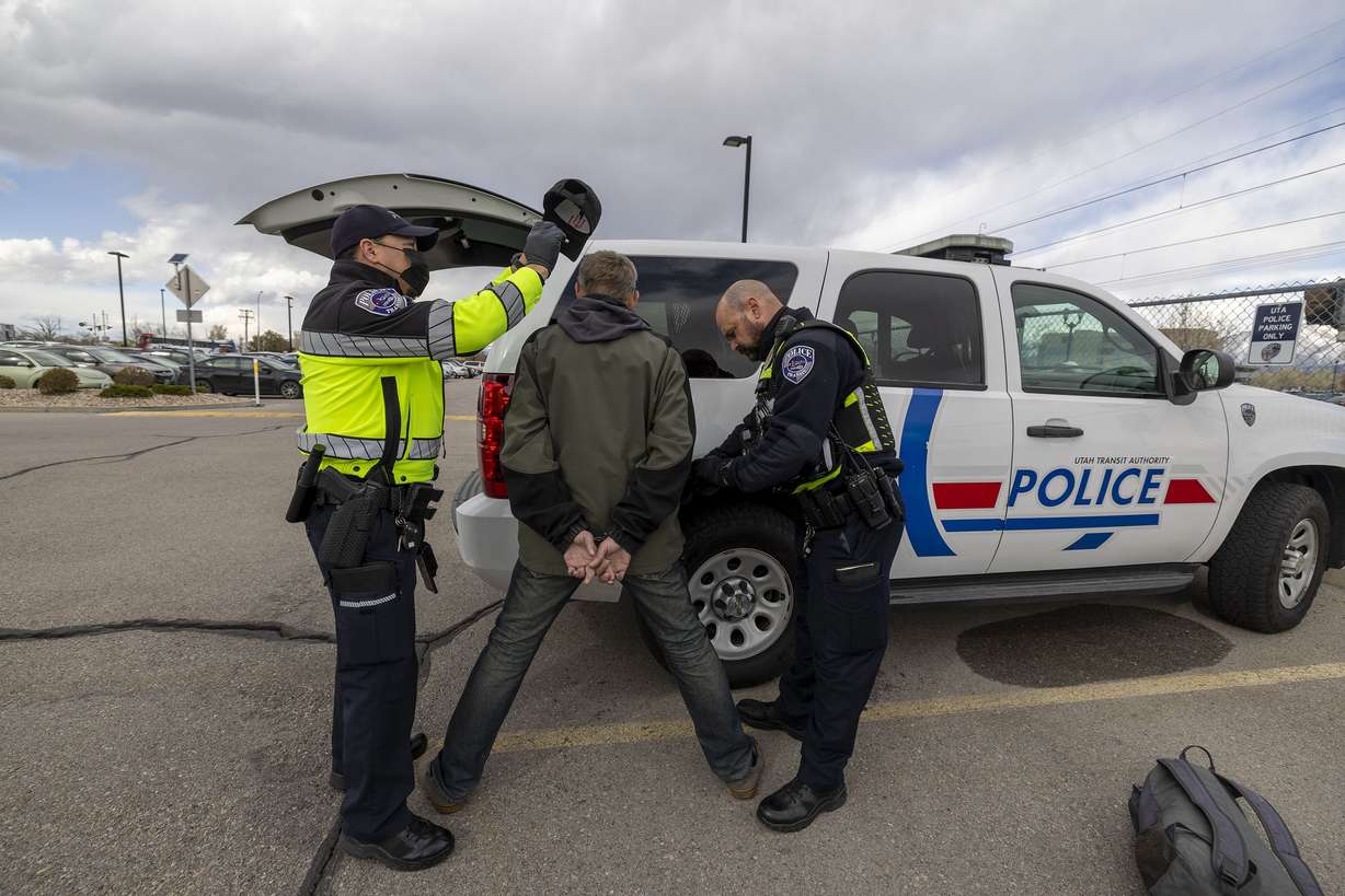 Utah Transit Authority police officers Phil Herrera and John Lobaido search a man they removed from a TRAX train after they verified he had felonies as they checked tickets in the Murray area on Wednesday.
