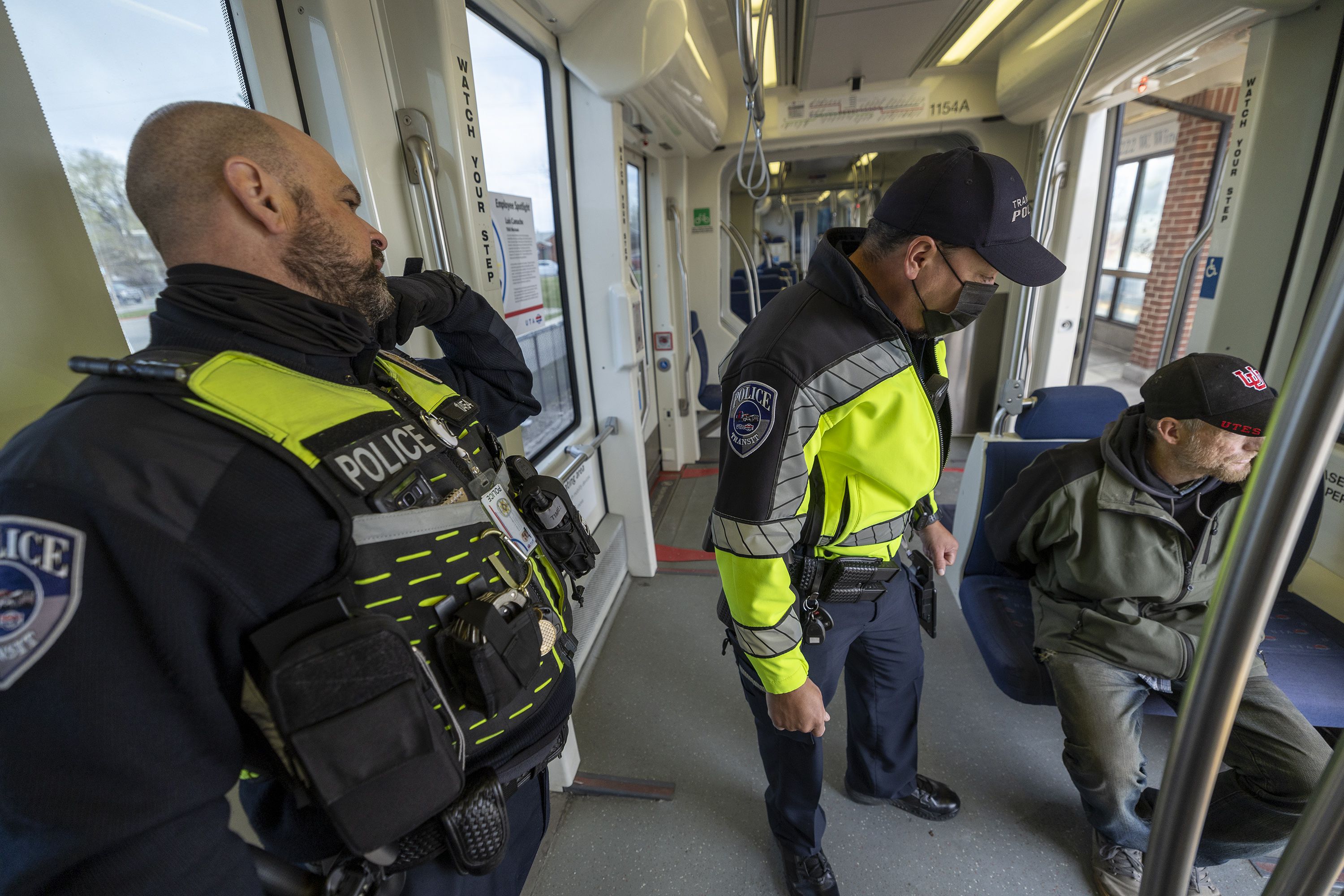 Utah Transit Authority police officers Phil Herrera and John Lobaido bring a man back to their office on a TRAX train after verifying that he had felonies as they checked tickets in the Murray area on Wednesday, April 13.