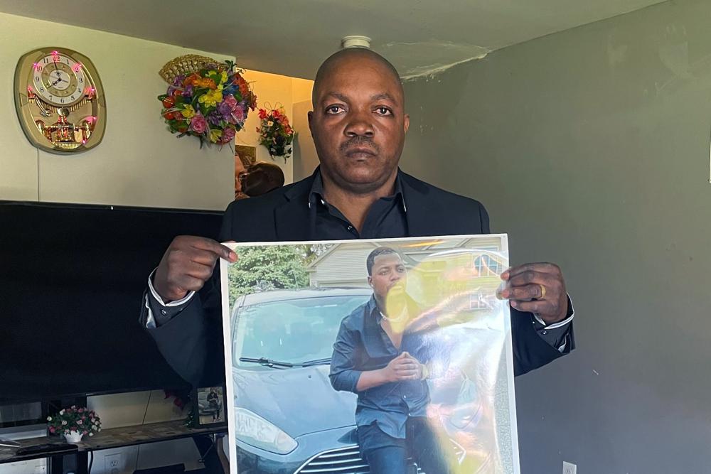 Peter Lyoya holds up a picture of his son Patrick Lyoya, 26, in his home in Lansing, Mich., Thursday. Grand Rapids police released four videos from different sources Wednesday, nine days after Patrick Lyoya was killed during a traffic stop. 