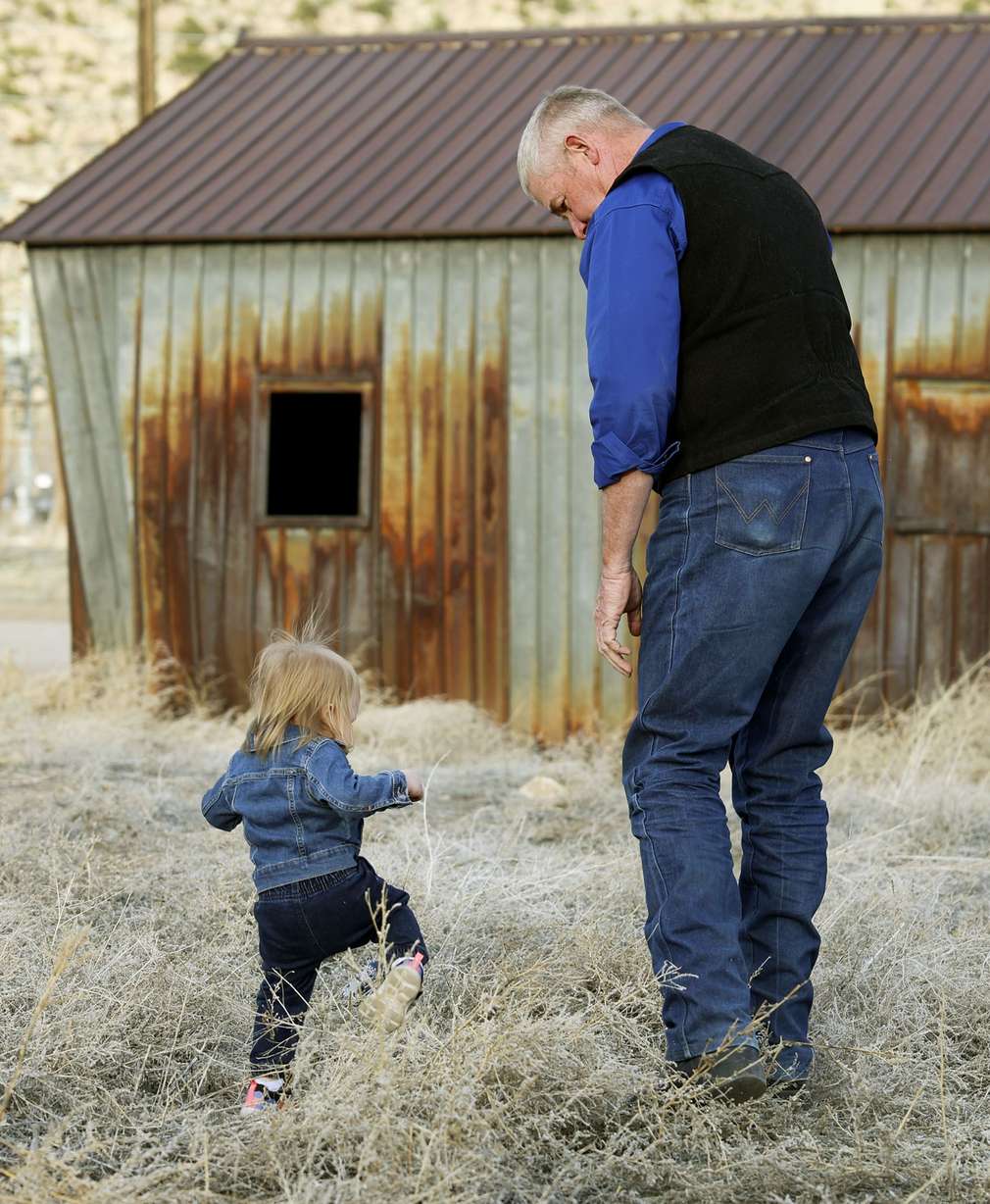 Scarlett Skiles, the daughter of Josie Powell, walks with Carbon County Sheriff’s detective Wally Hendricks near Price on Sunday, April 3.