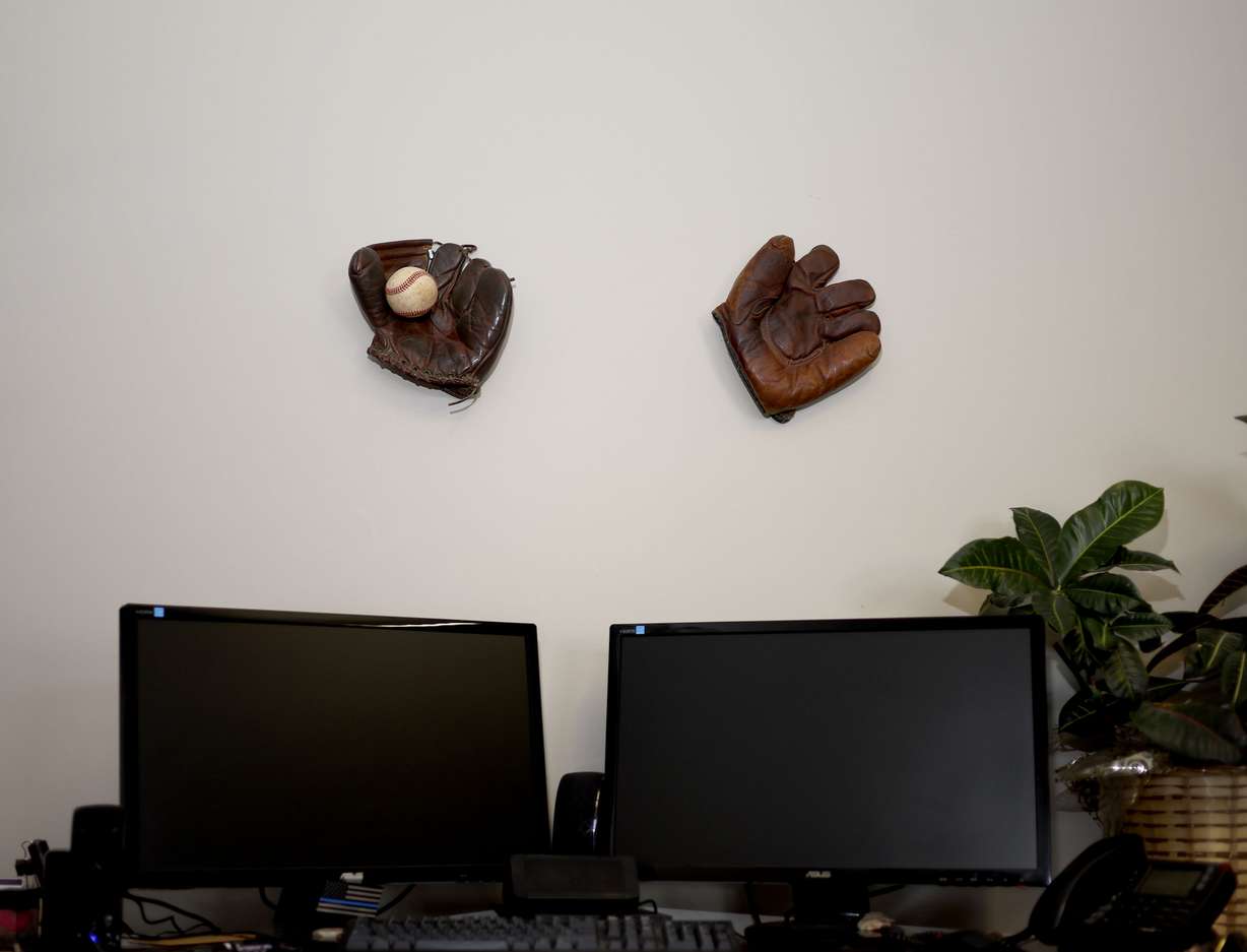 Baseball mitts are displayed above detective Travis Henrie’s desk in the Carbon County detectives office in Price on Sunday, April 3. Something of Price’s small-town, rural heritage is deliberately reflected in the décor of the officers’ open-plan office.