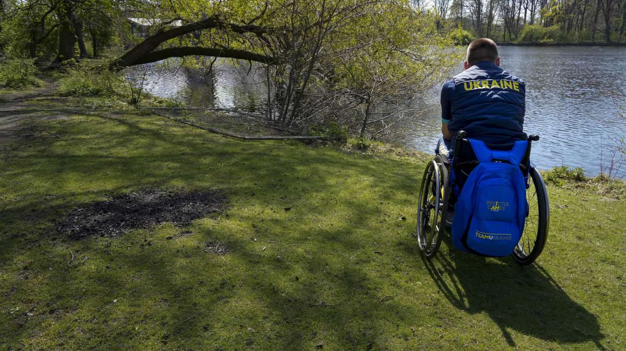 A member of Team Ukraine looks out over a lake at the Invictus Games venue in The Hague, Netherlands, Thursday, April 14, 2022. The week-long games for active servicemen and veterans who are ill, injured or wounded opens Saturday in this Dutch city that calls itself the global center of peace and justice. Those concepts seem a world away to the team of 19 athletes from Ukraine.