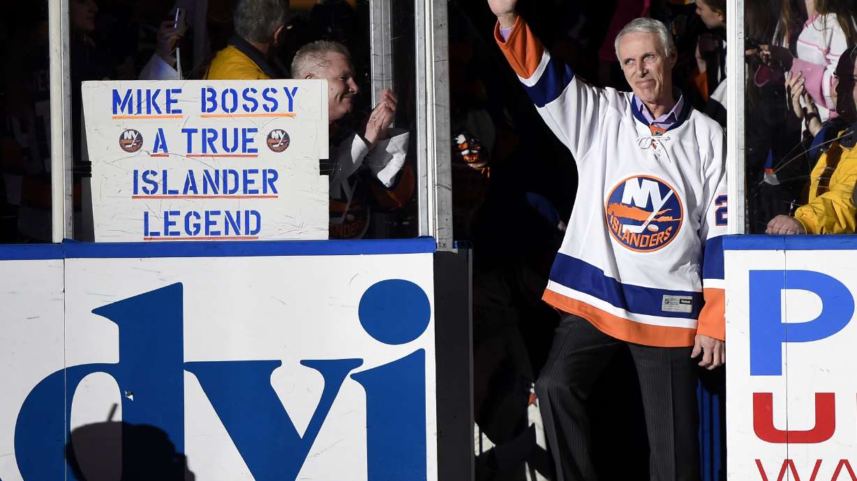 FILE - Hockey Hall of Famer and former New York Islander Mike Bossy waves to fans as he is introduced before the NHL hockey game between the Islanders and the Boston Bruins at Nassau Coliseum on Thursday, Jan. 29, 2015, in Uniondale, N.Y. Bossy dropped a ceremonial first puck. Bossy, one of hockey’s most prolific goal-scorers and a star for the New York Islanders during their 1980s dynasty, died Friday, April 15, 2022, after a battle with lung cancer. He was 65.