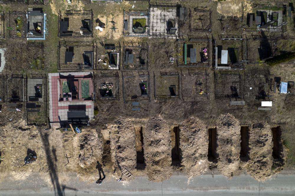 A cemetery worker takes a rest from working on the graves of civilians killed in Bucha during the war with Russia, in the outskirts of Kyiv, Ukraine, Thursday. More than 900 bodies of civilians were discovered in the Kyiv region following the withdrawal of Russian forces.