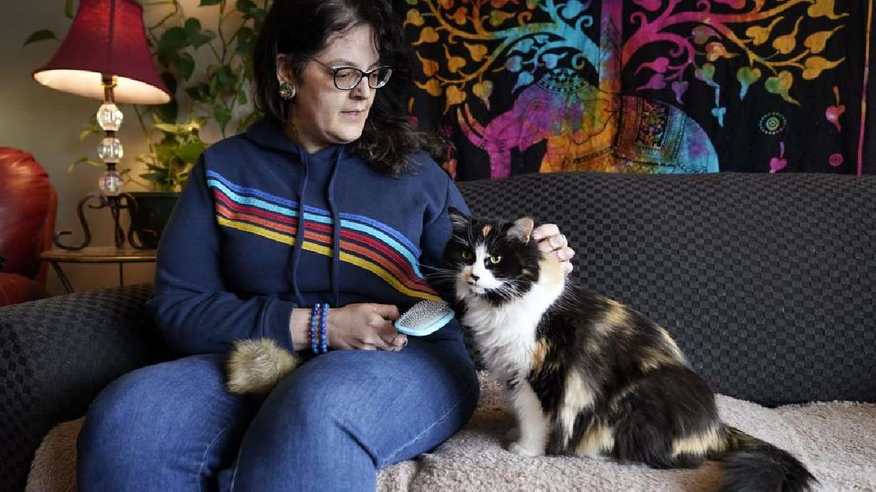 Tara Kramer sits in her apartment with her cat Busy, April 8, in Des Moines, Iowa. More of the roughly 40 million Americans who get help buying food through the federal SNAP program are seeing their benefits plunge even as the nation struggles with the biggest increase in food costs in decades.